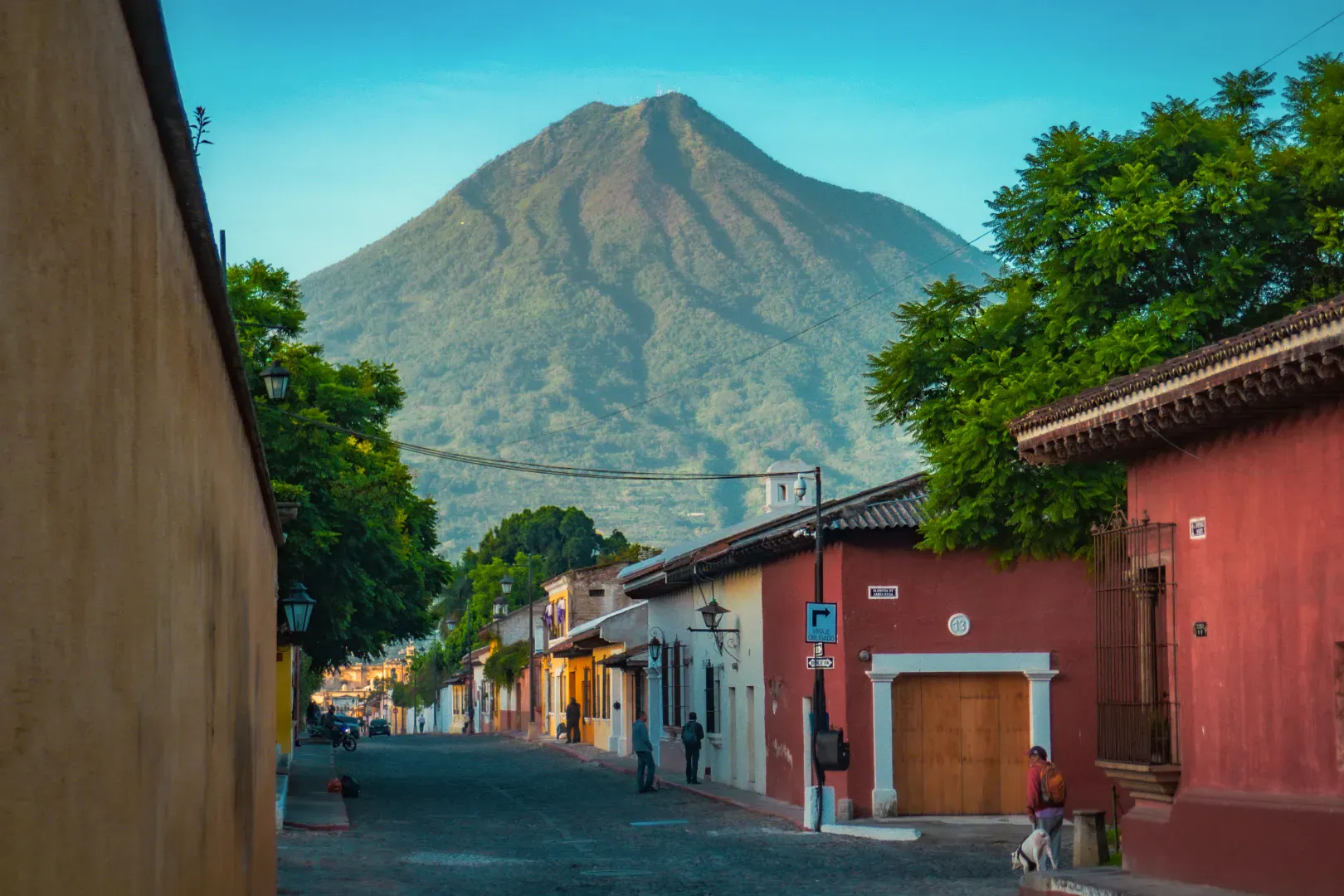 Strada coloniale in Guatemala con case colorate e un vulcano sullo sfondo