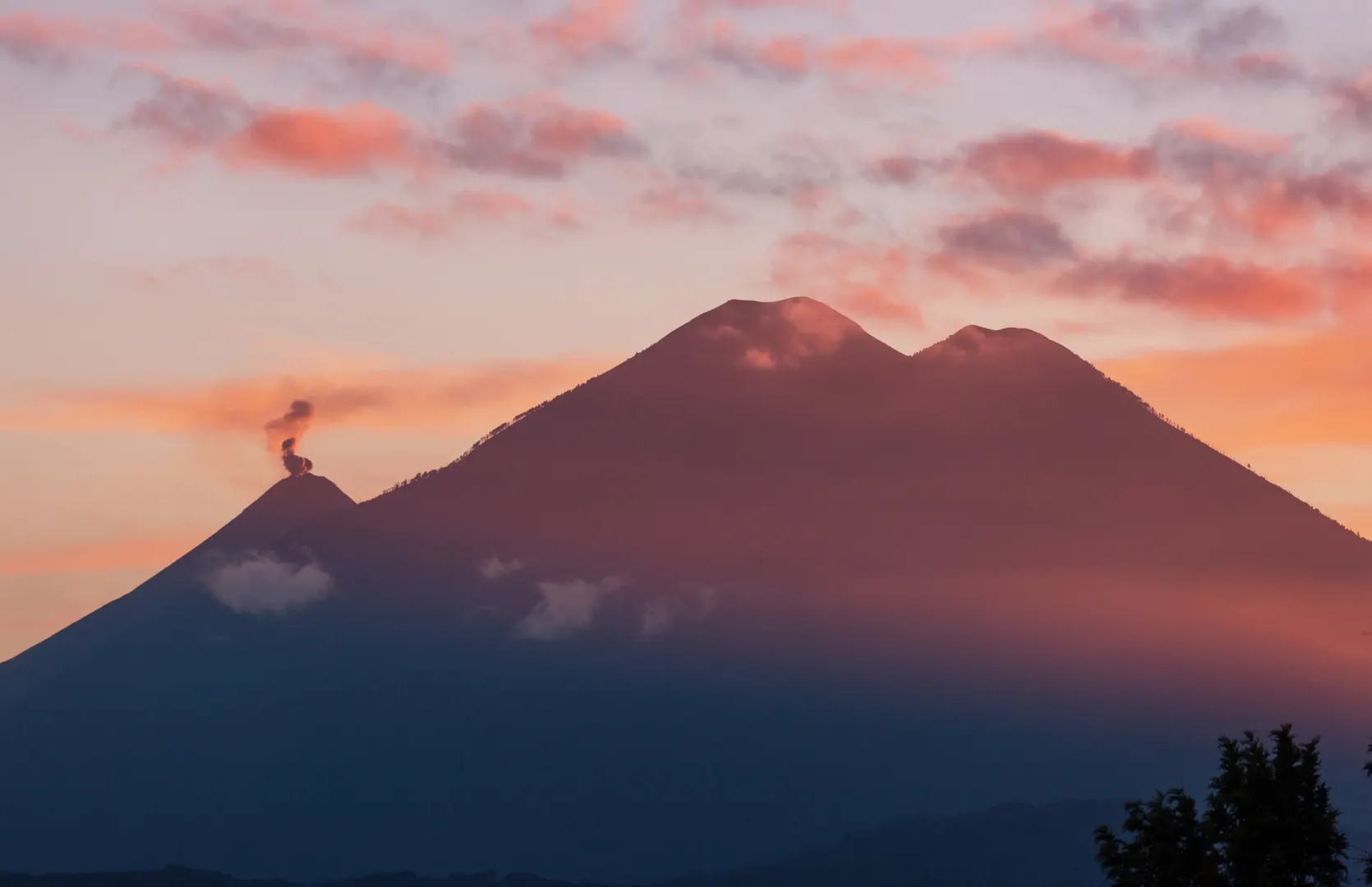 Vulcani in Guatemala al tramonto sotto un cielo colorato e nuvole sulle montagne