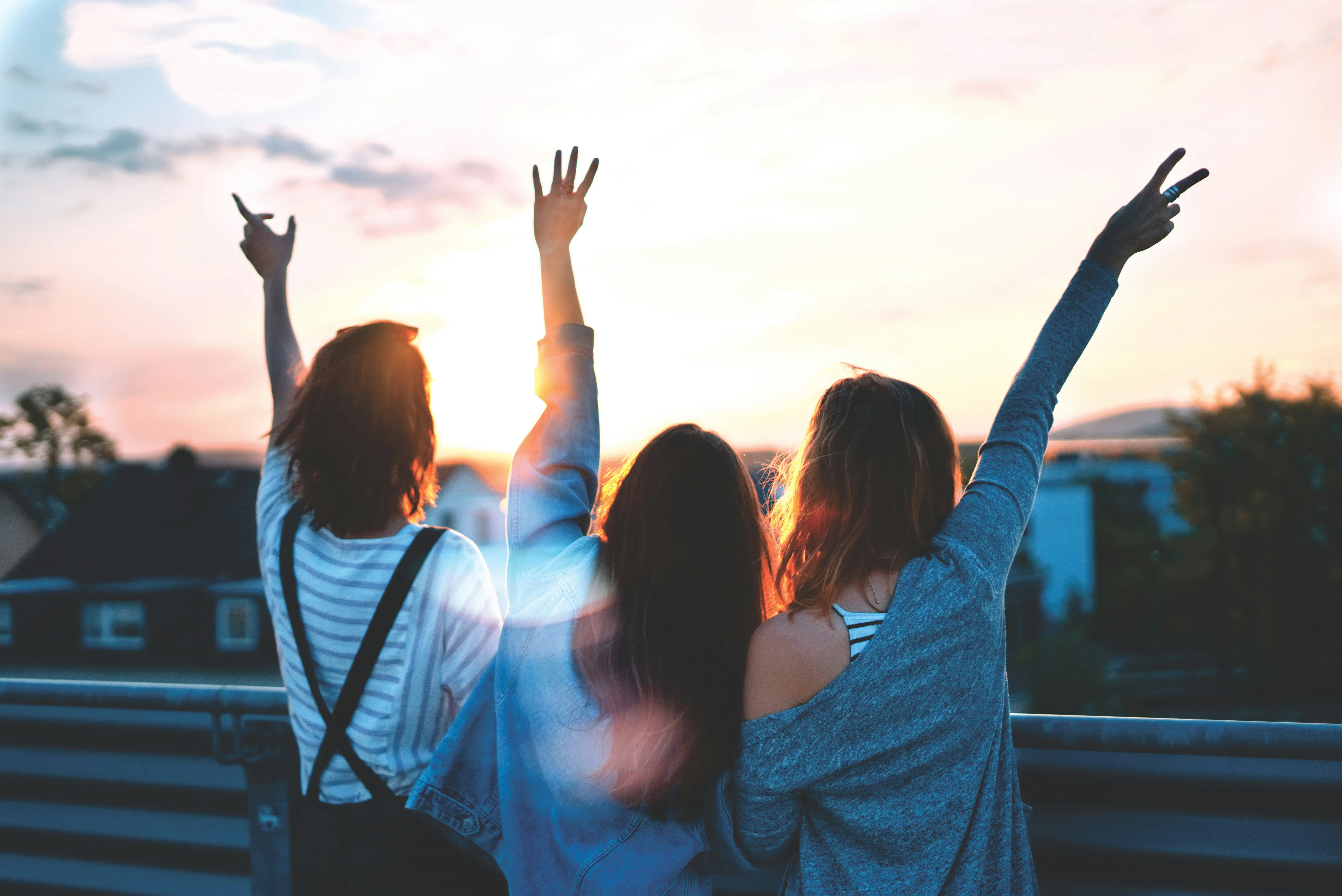 Foto de três mulheres levantando as mãos