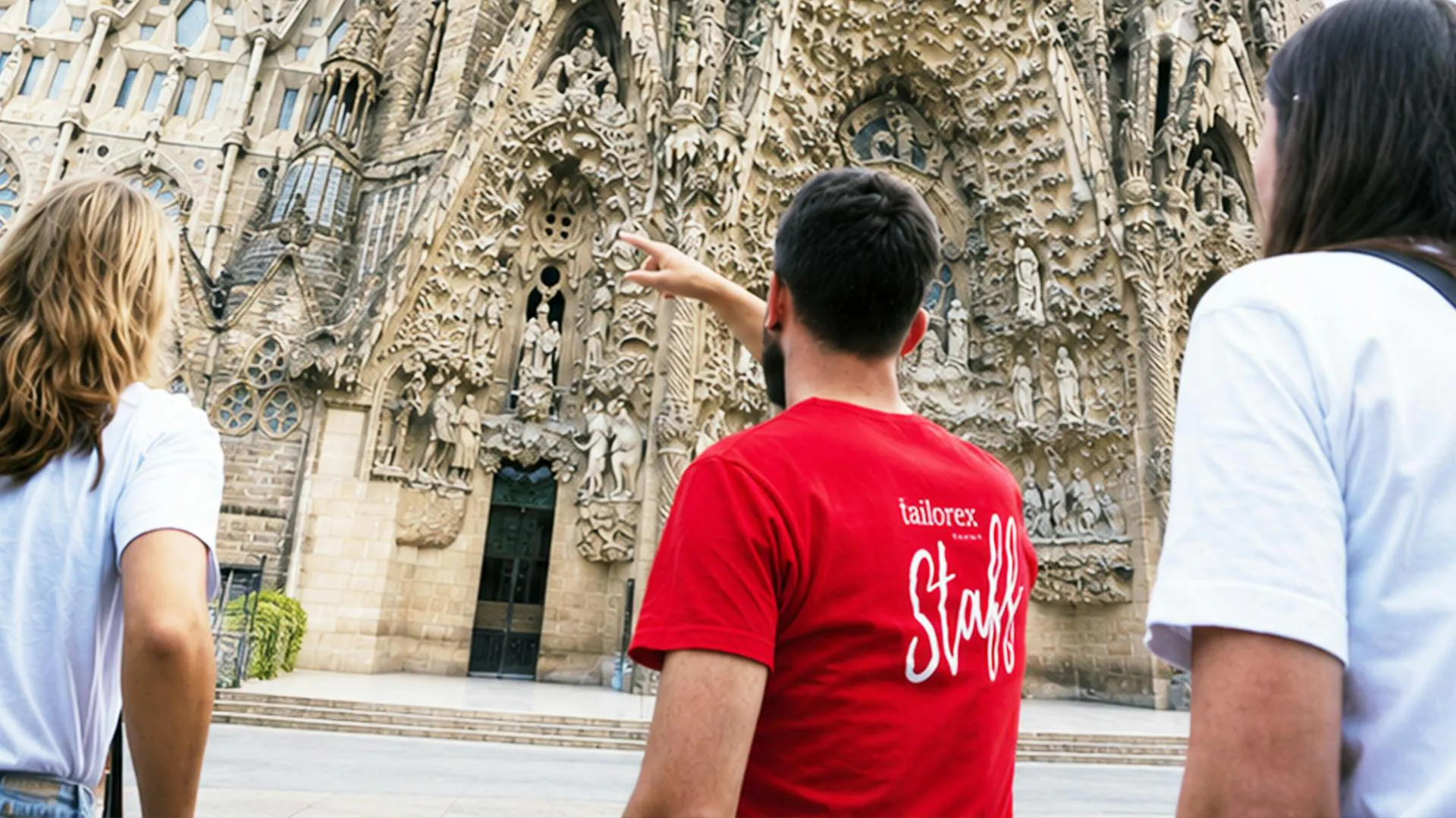 Animatore del camp con maglietta dello staff che spiega la Sagrada Família durante un’attività culturale