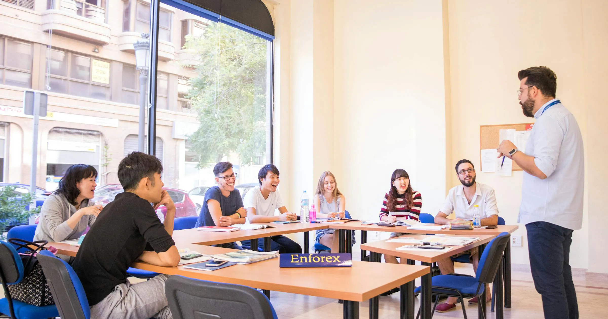 Docente che presenta agli studenti durante una discussione in aula in un luminoso e moderno ambiente di apprendimento.