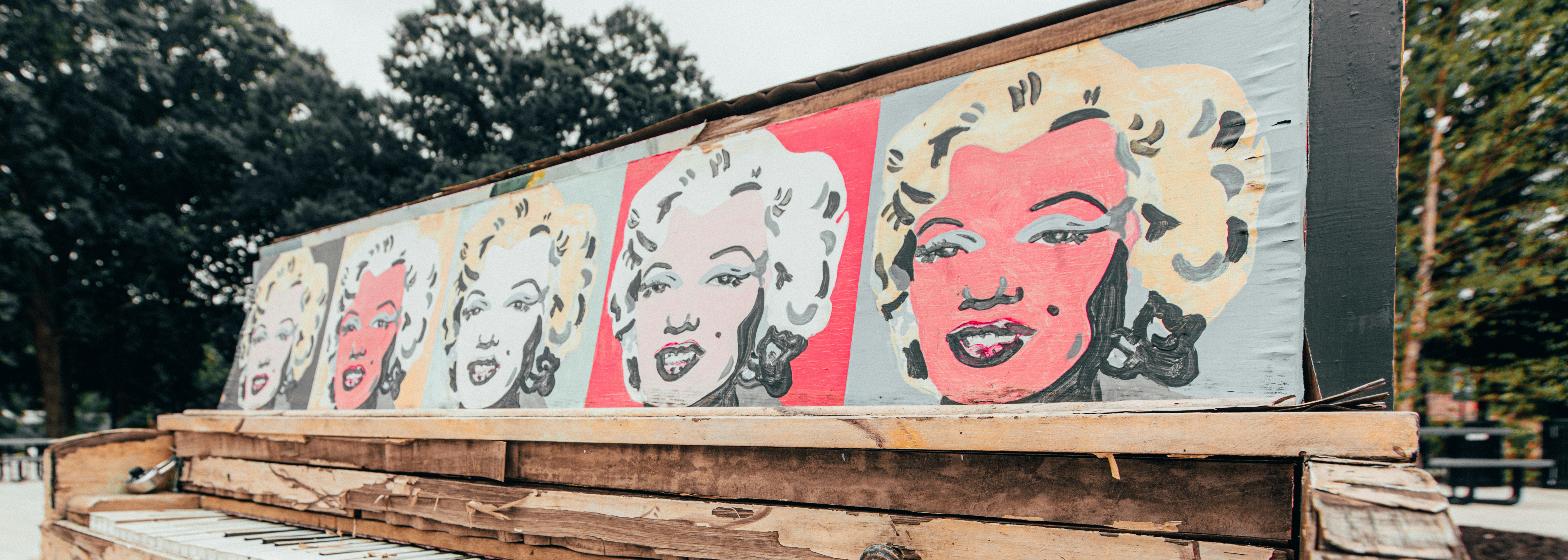 white and red graffiti on brown wooden fence