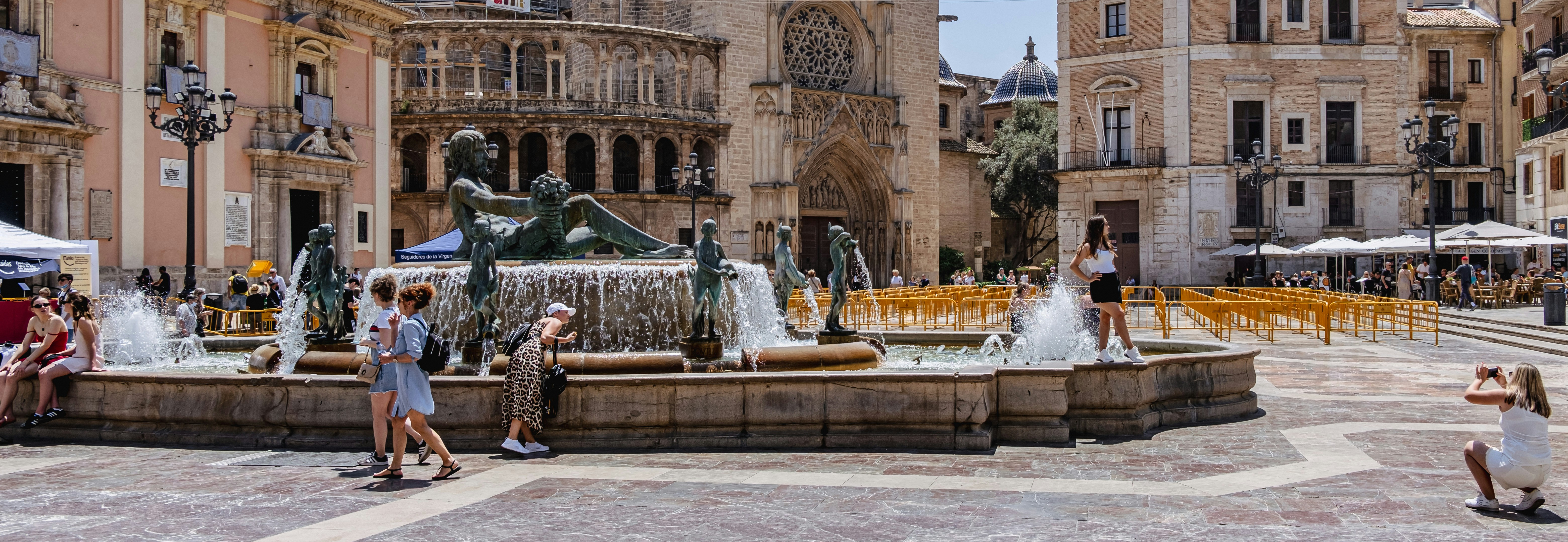 a fountain in a courtyard with buildings in the background
