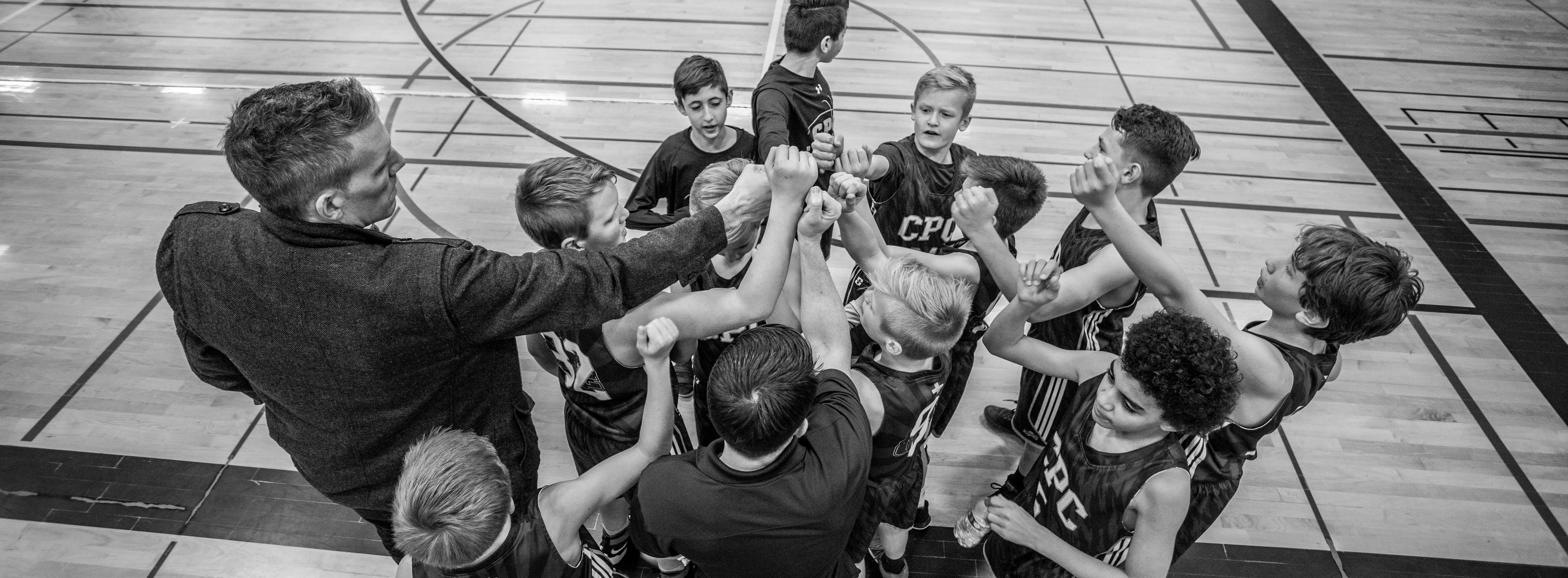 grayscale photography of boys raising hand