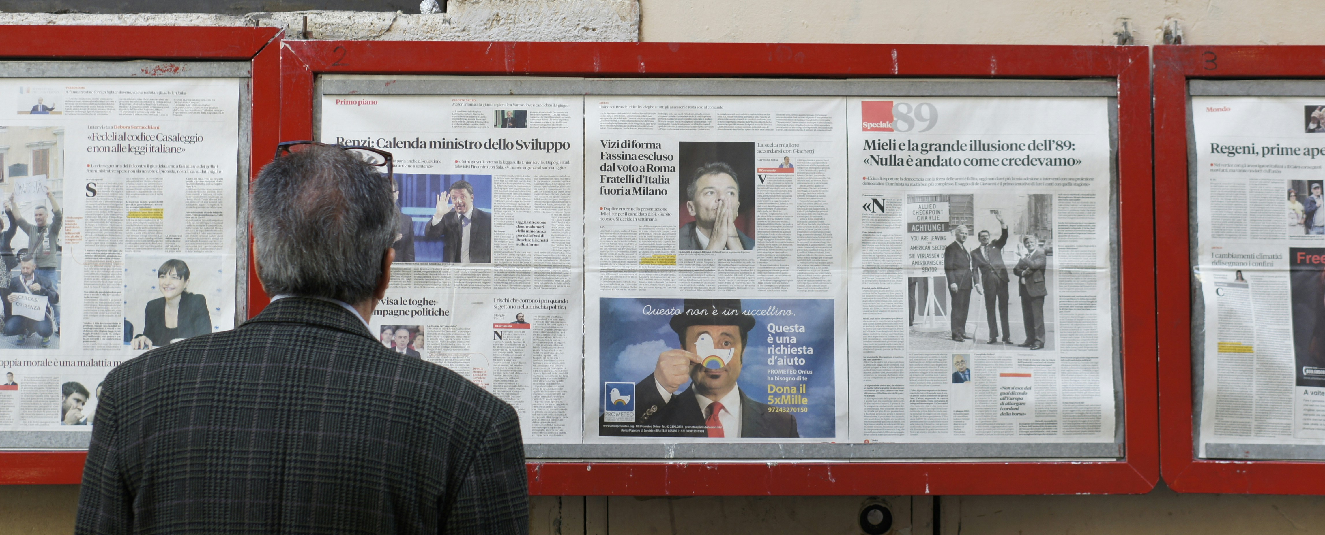 man reading newspaper in bulletin board