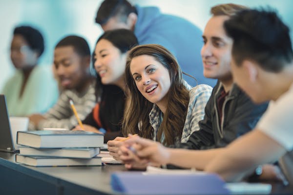 Classe di spagnolo multiculturale con diversi studenti internazionali e uno studente sorridente