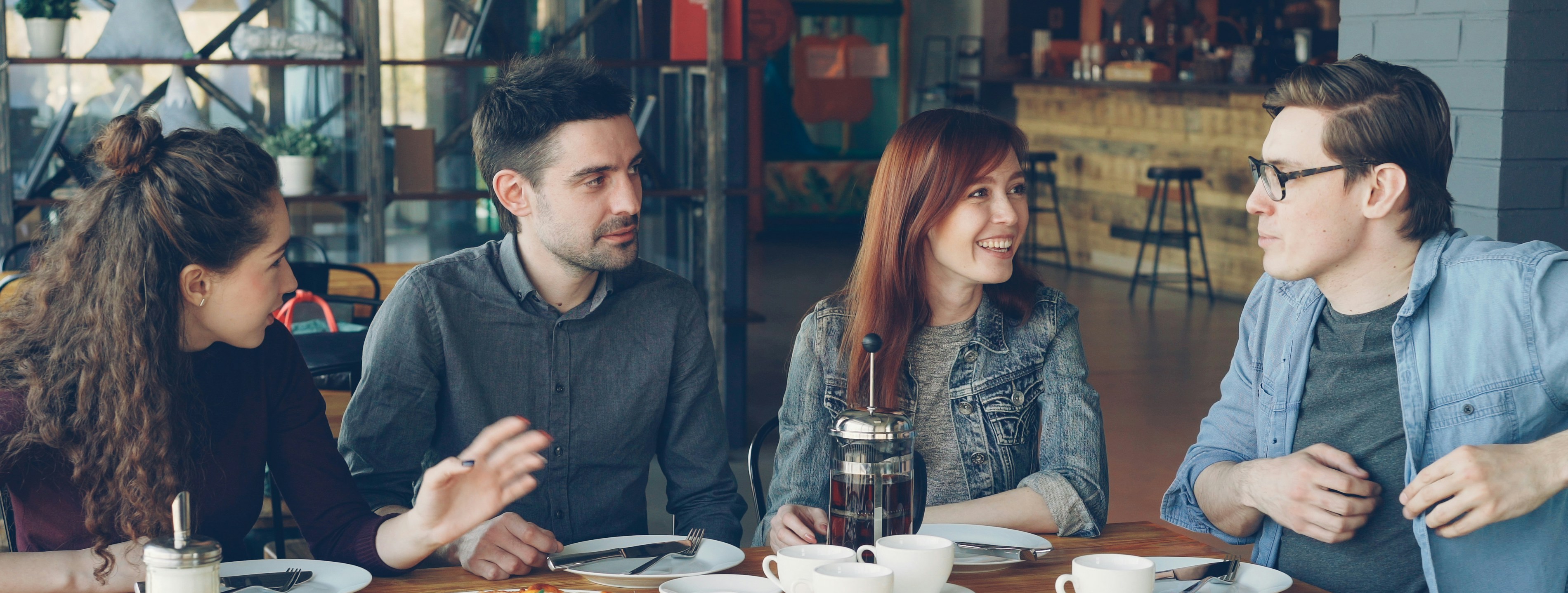 Amici condividono pizza e conversazione in un ristorante.