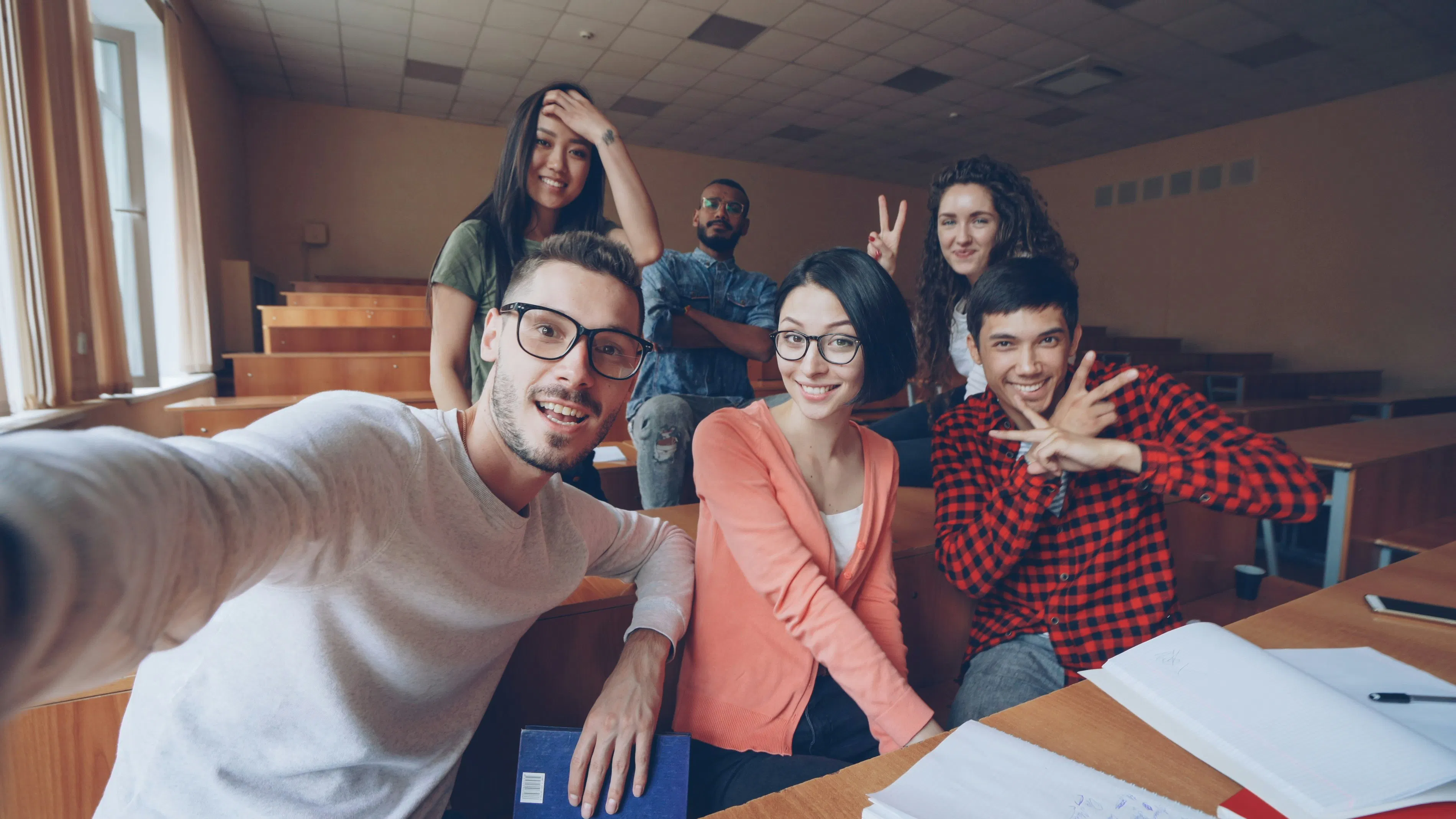 Gruppo di studenti sorridenti che si scattano un selfie in aula
