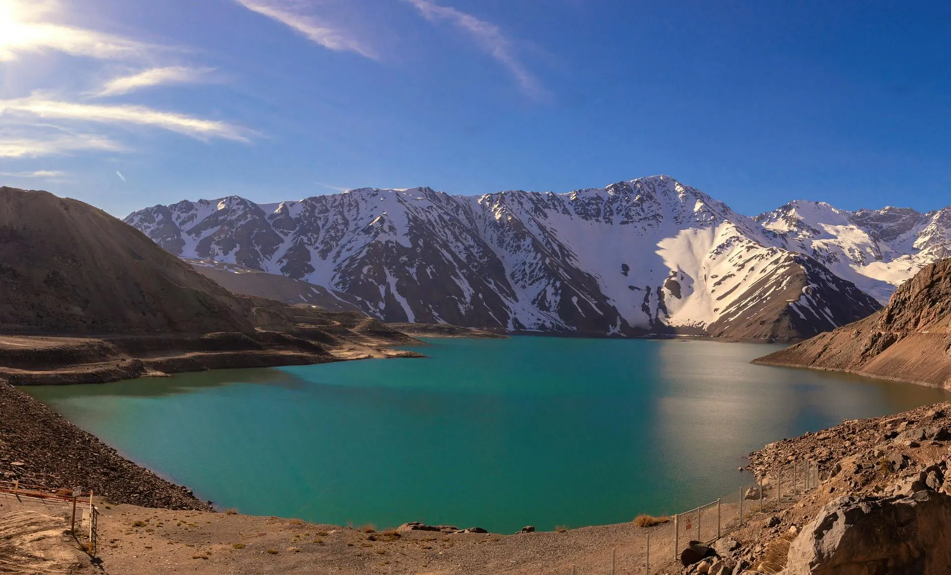 Lago di montagna circondato da vette innevate in un sorprendente paesaggio naturale andino