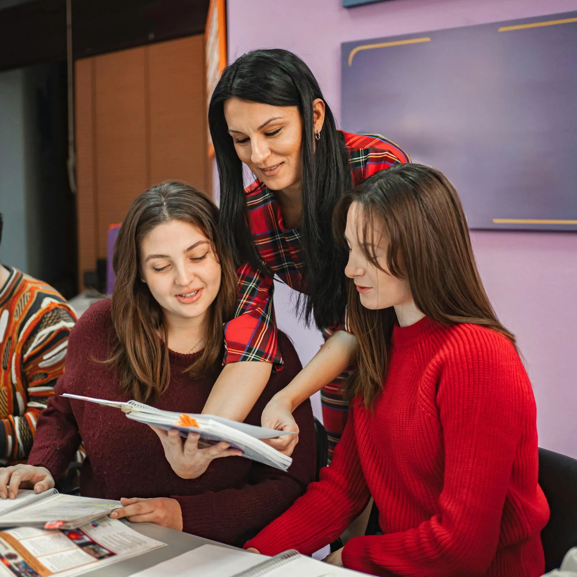 Insegnante che aiuta gli studenti durante un'attività di gruppo in aula