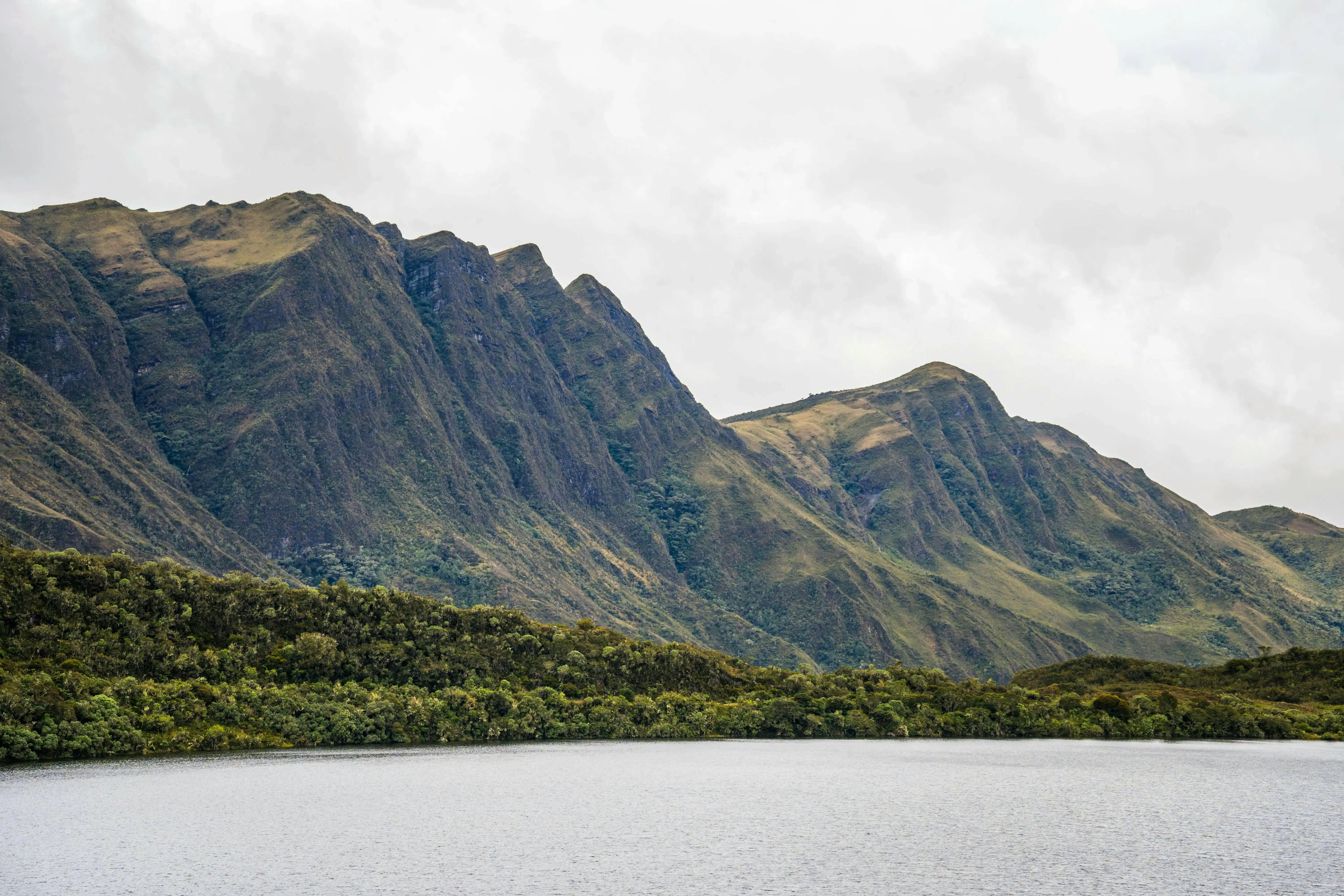 Paesaggio naturale in Colombia con montagne verdi e un lago sotto un cielo nuvoloso