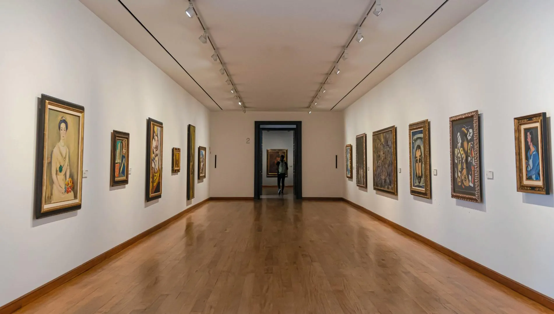 Galleria museale con dipinti esposti in uno spazio d'arte luminoso e moderno