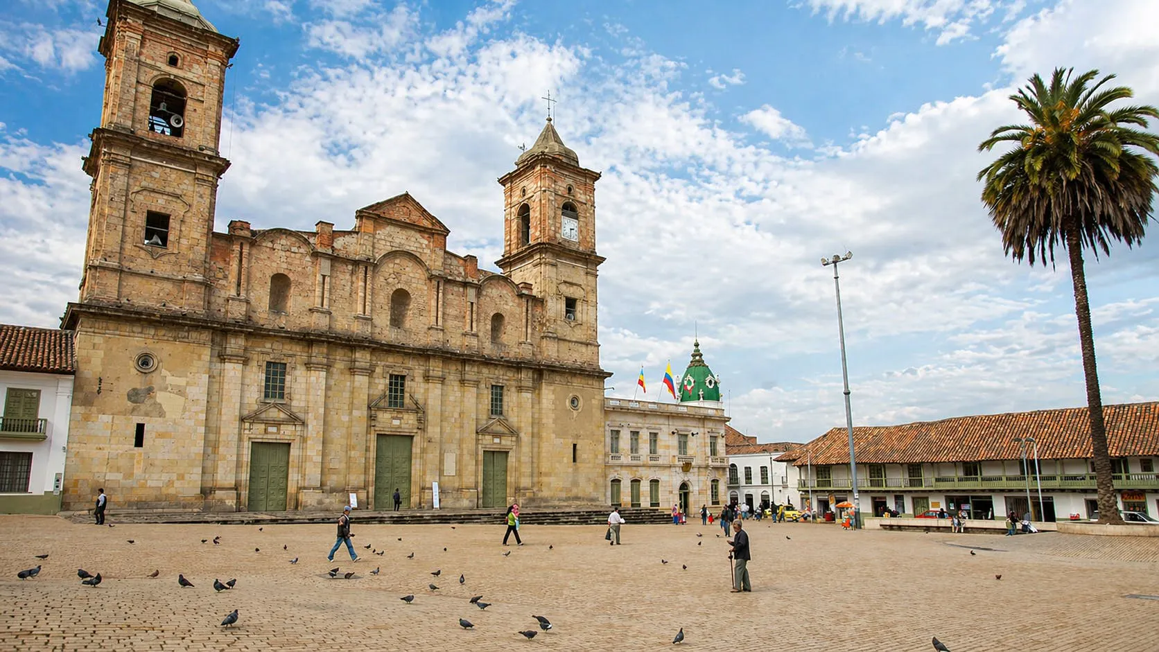Piazza storica a Bogotà con una cattedrale coloniale, palme ed edifici tradizionali