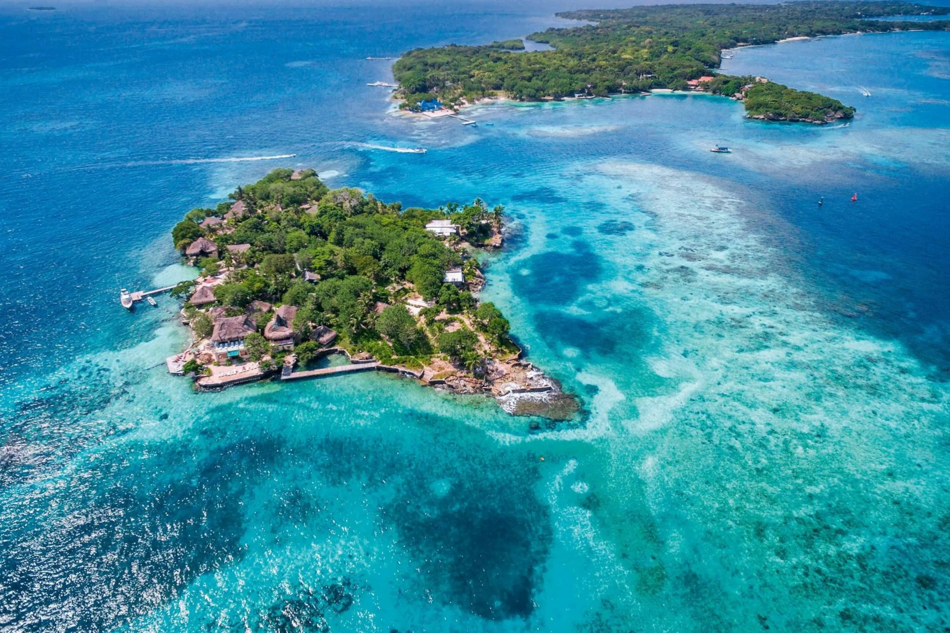 Isola tropicale circondata da acque turchesi e barriere coralline nel Mar dei Caraibi