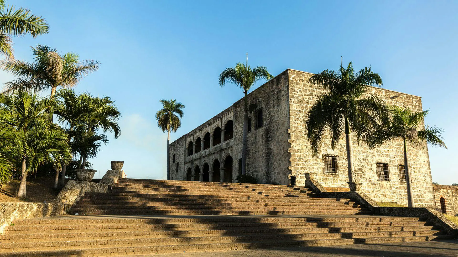 Monumento storico in pietra circondato da palme nella Repubblica Dominicana