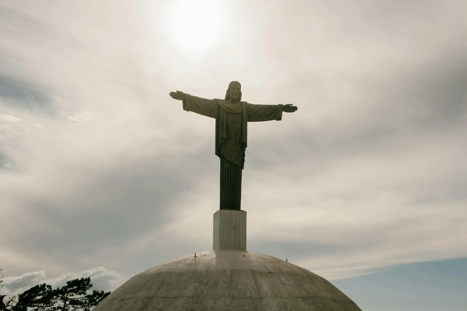 Statua monumentale del Cristo sulla cima di una cupola sotto un cielo nuvoloso nella Repubblica Dominicana