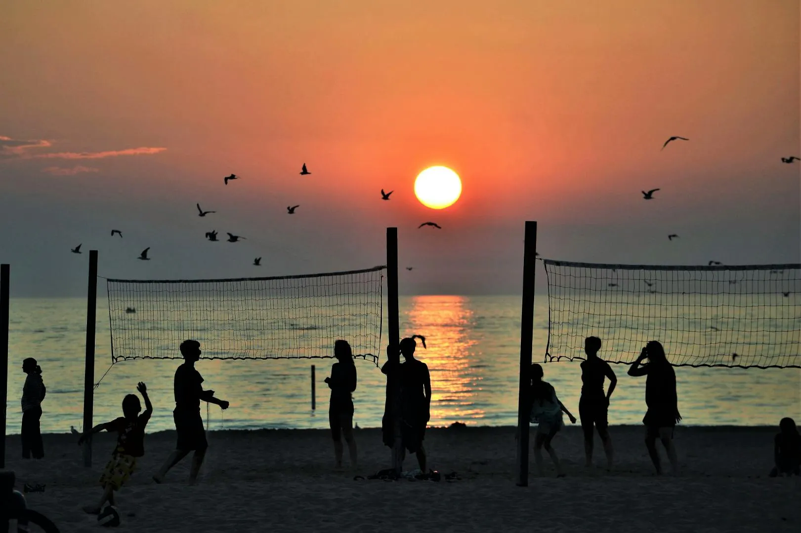 Persone che godono del tramonto su una spiaggia della Repubblica Dominicana al mare