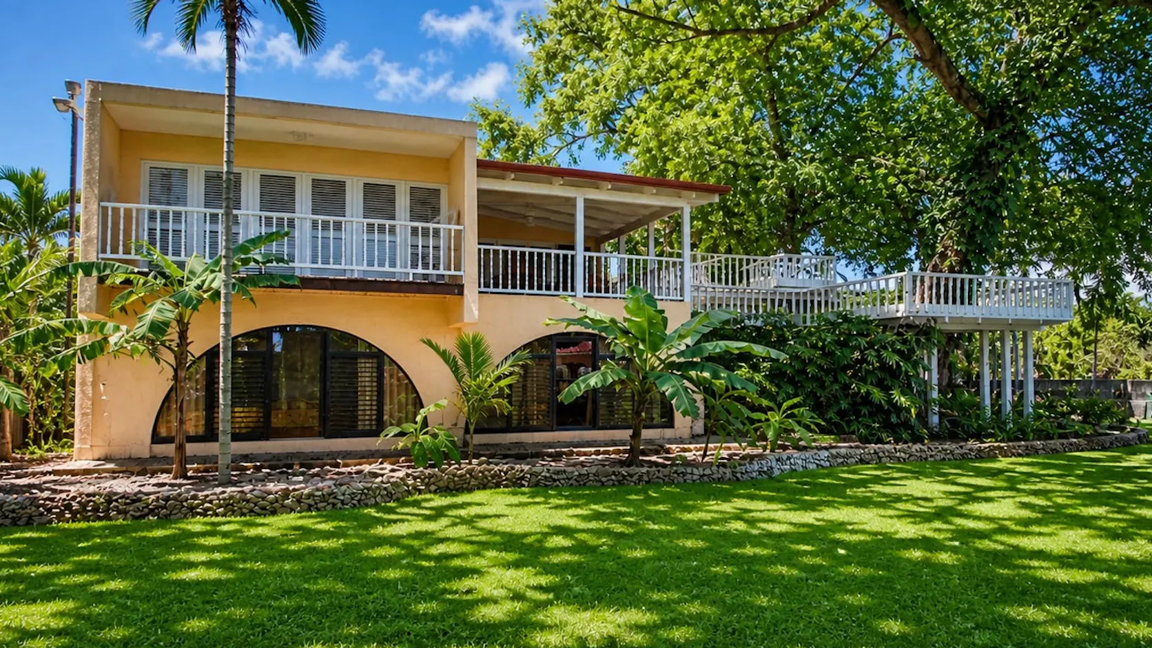 Casa tropicale circondata da giardini e palme in un tranquillo ambiente naturale