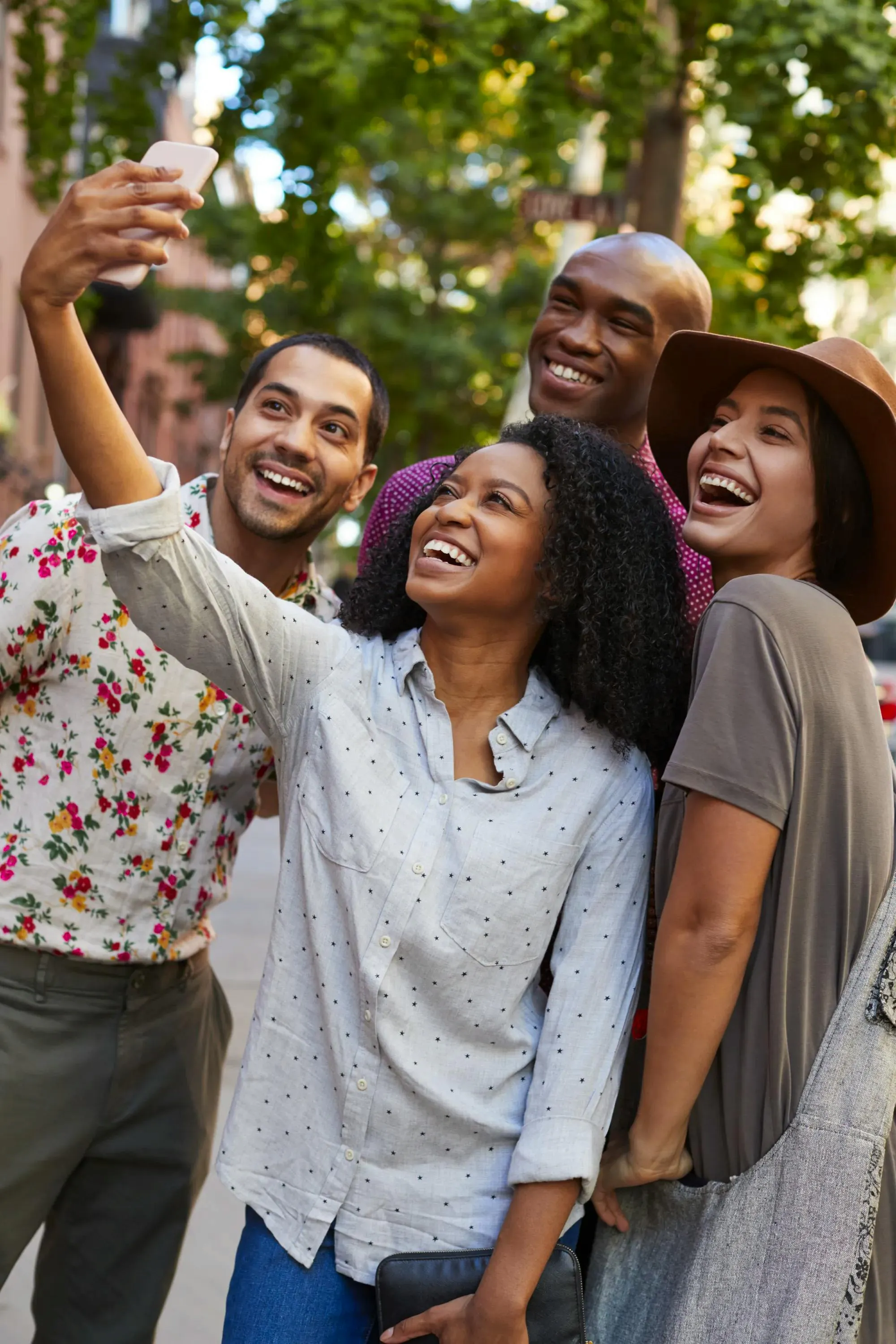 Gruppo di amici che sorridono mentre scattano un selfie all'aperto