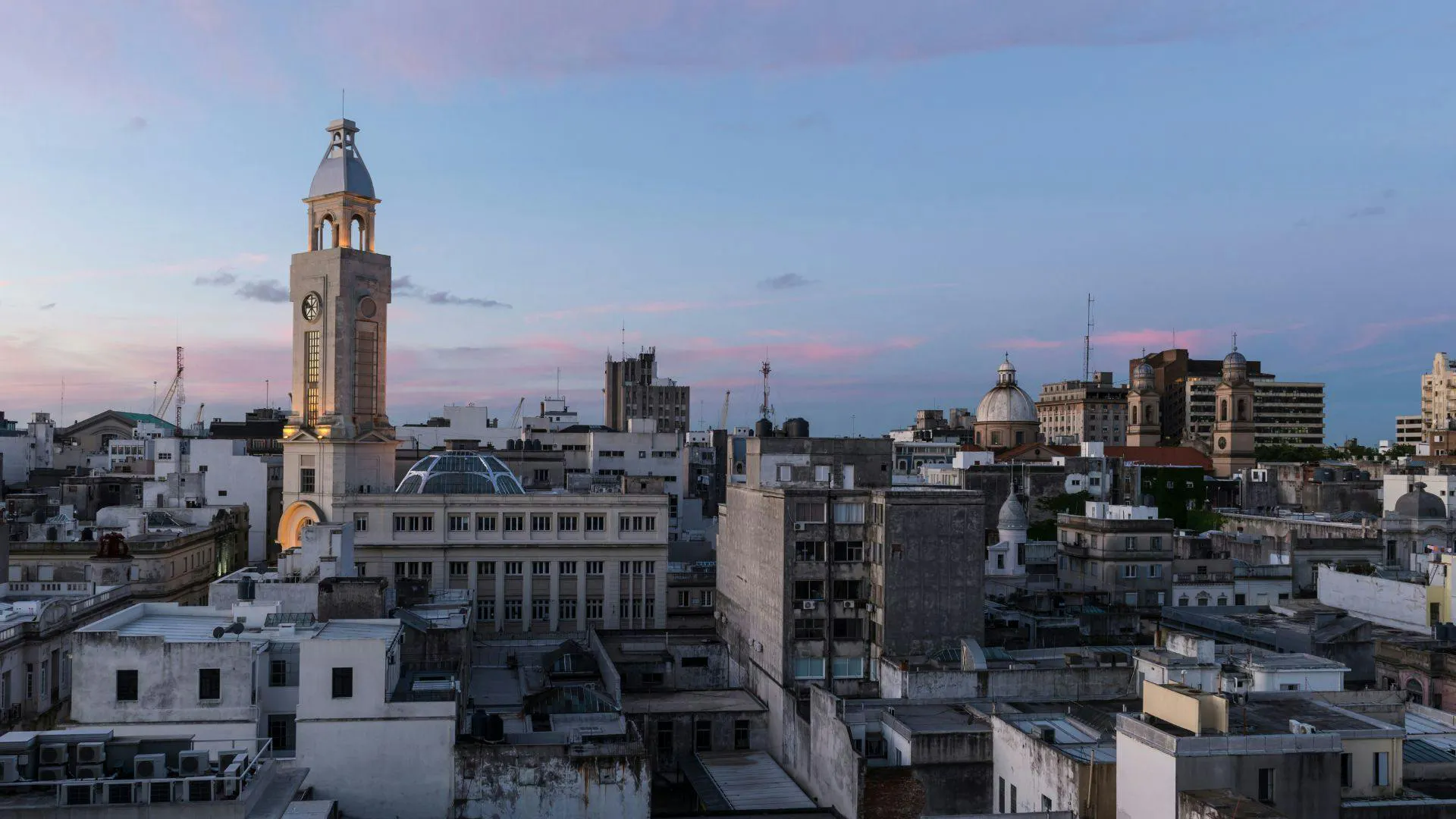 Città uruguaiana con edifici storici e una torre iconica al tramonto