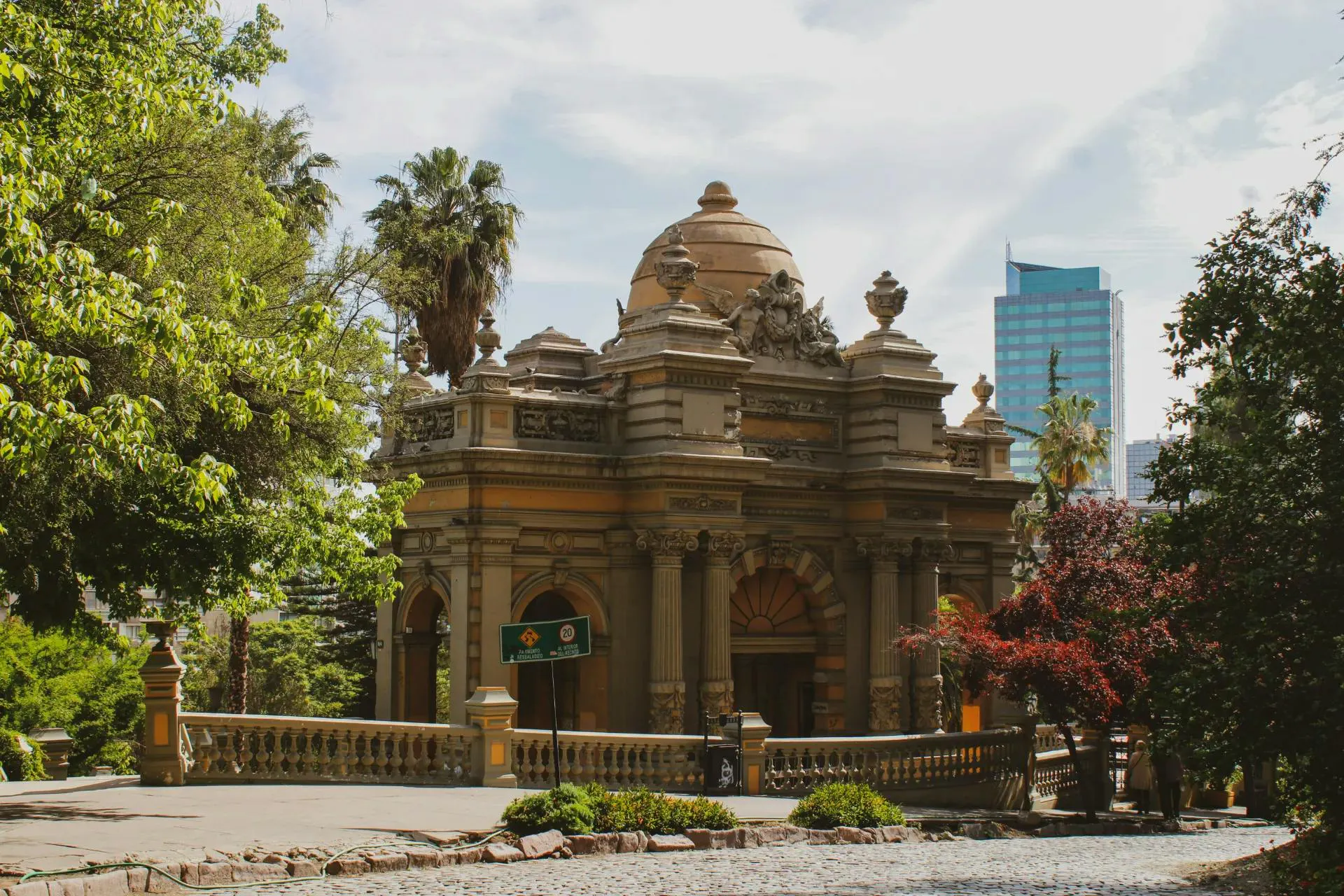 Edificio storico circondato da giardini e alberi in un'area urbana moderna