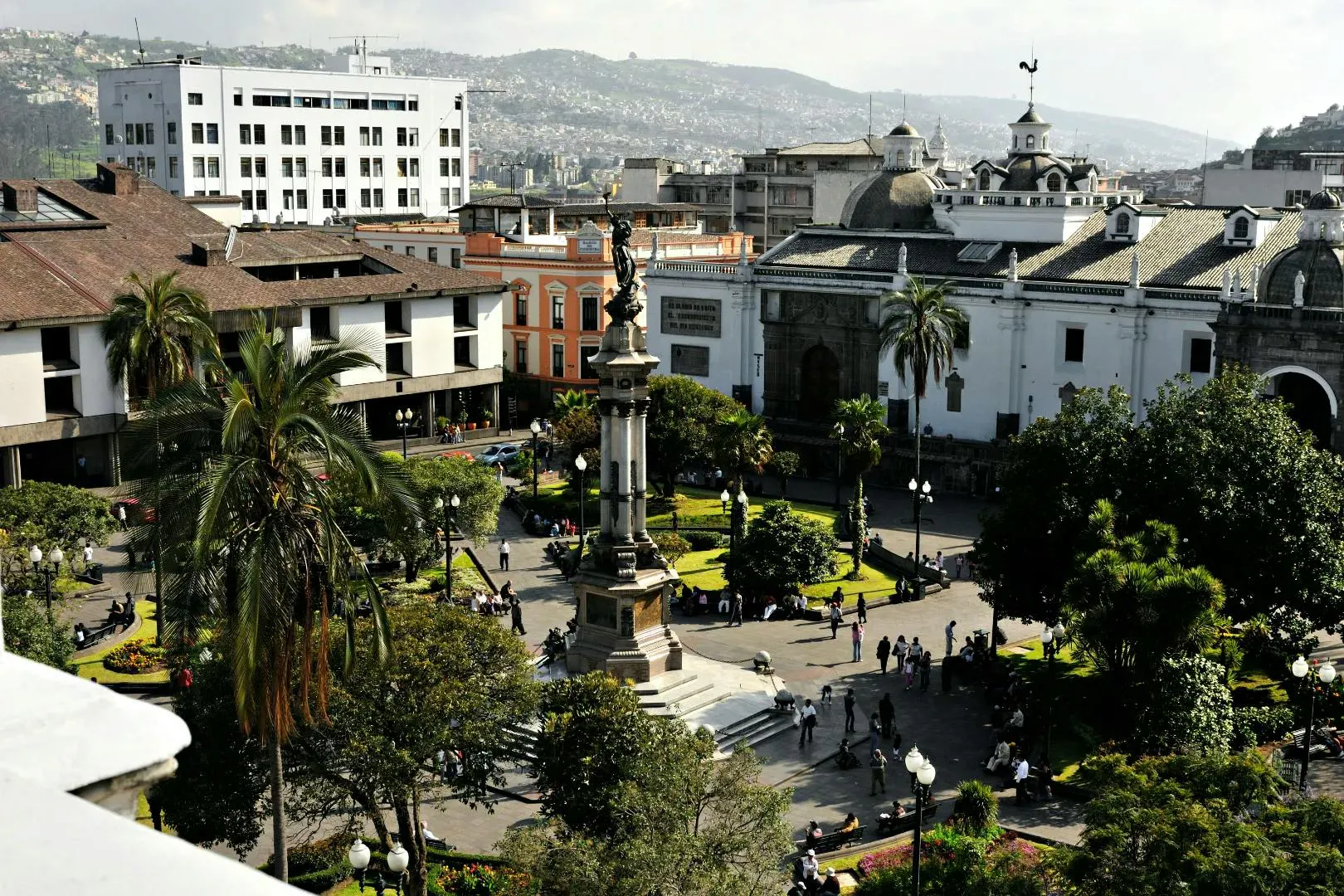 Piazza storica in Ecuador con giardini, edifici coloniali e persone che passeggiano