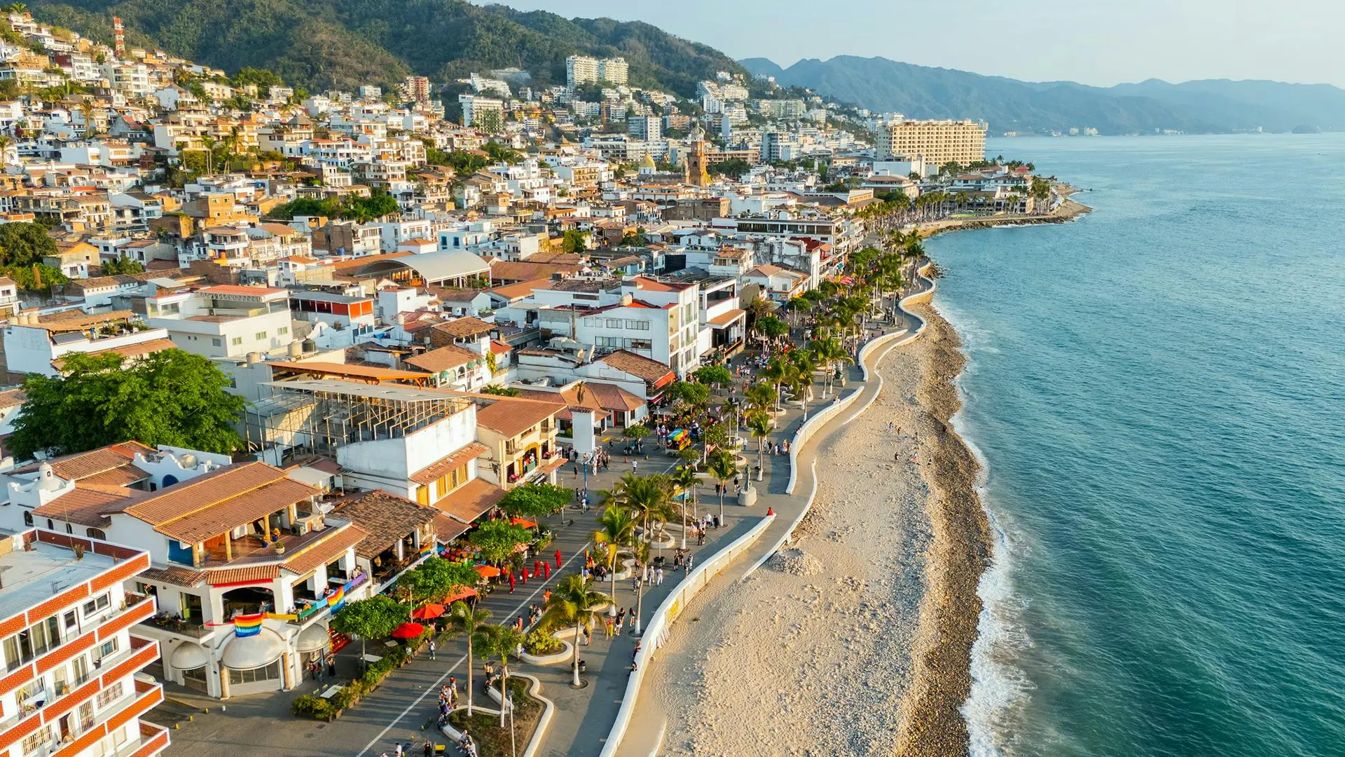 Veduta aerea di una città costiera con spiaggia, lungomare e edifici sull'oceano