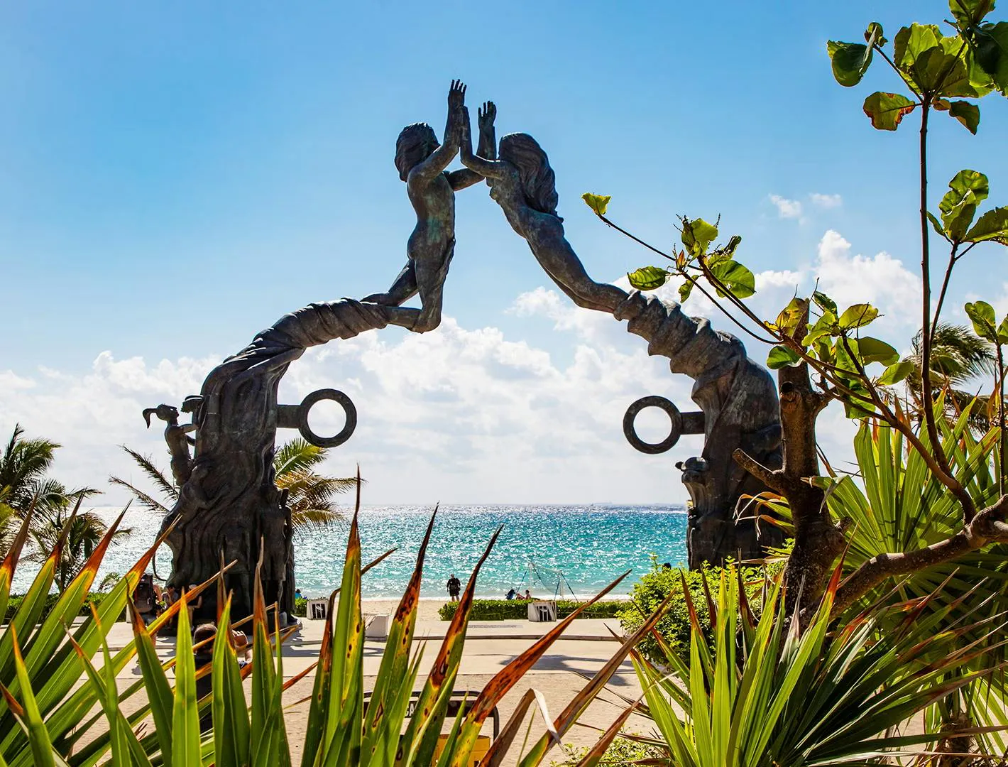Scultura sul mare su una spiaggia tropicale circondata da palme e vegetazione lussureggiante