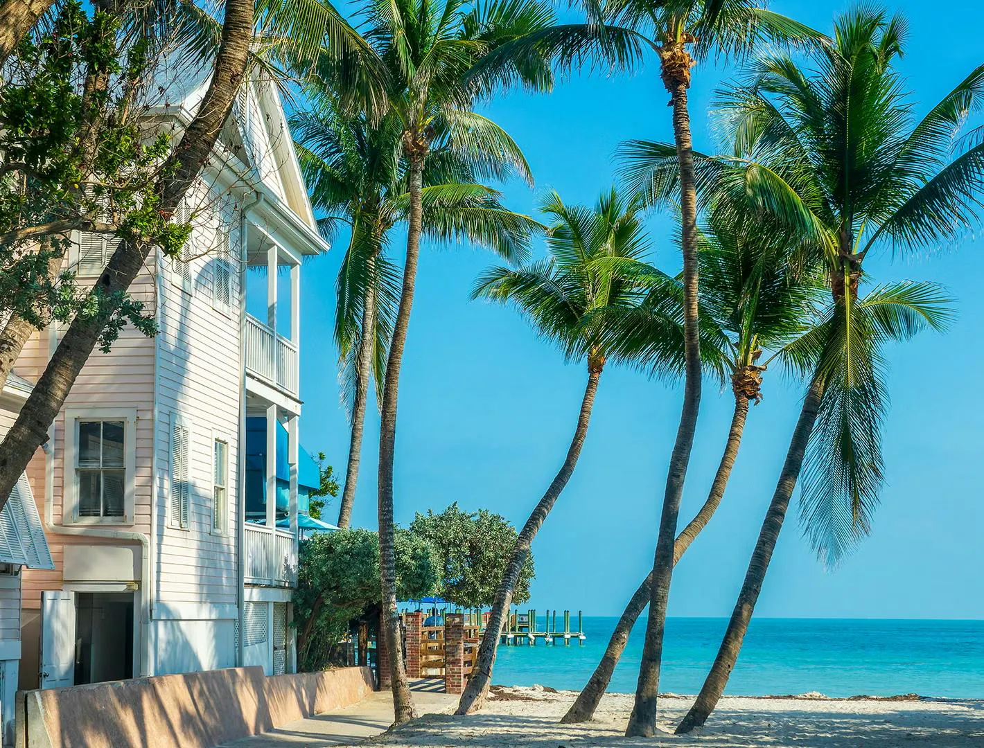Casa sul lungomare circondata da palme e acque tropicali cristalline