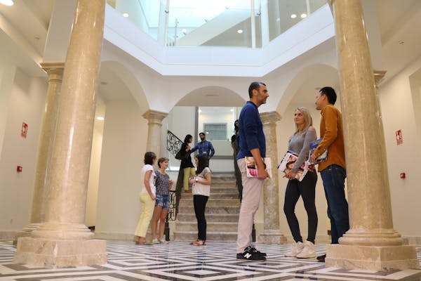 Studenti che interagiscono nell'area d'ingresso di una scuola Enforex, creando un'atmosfera di campus accogliente e sociale