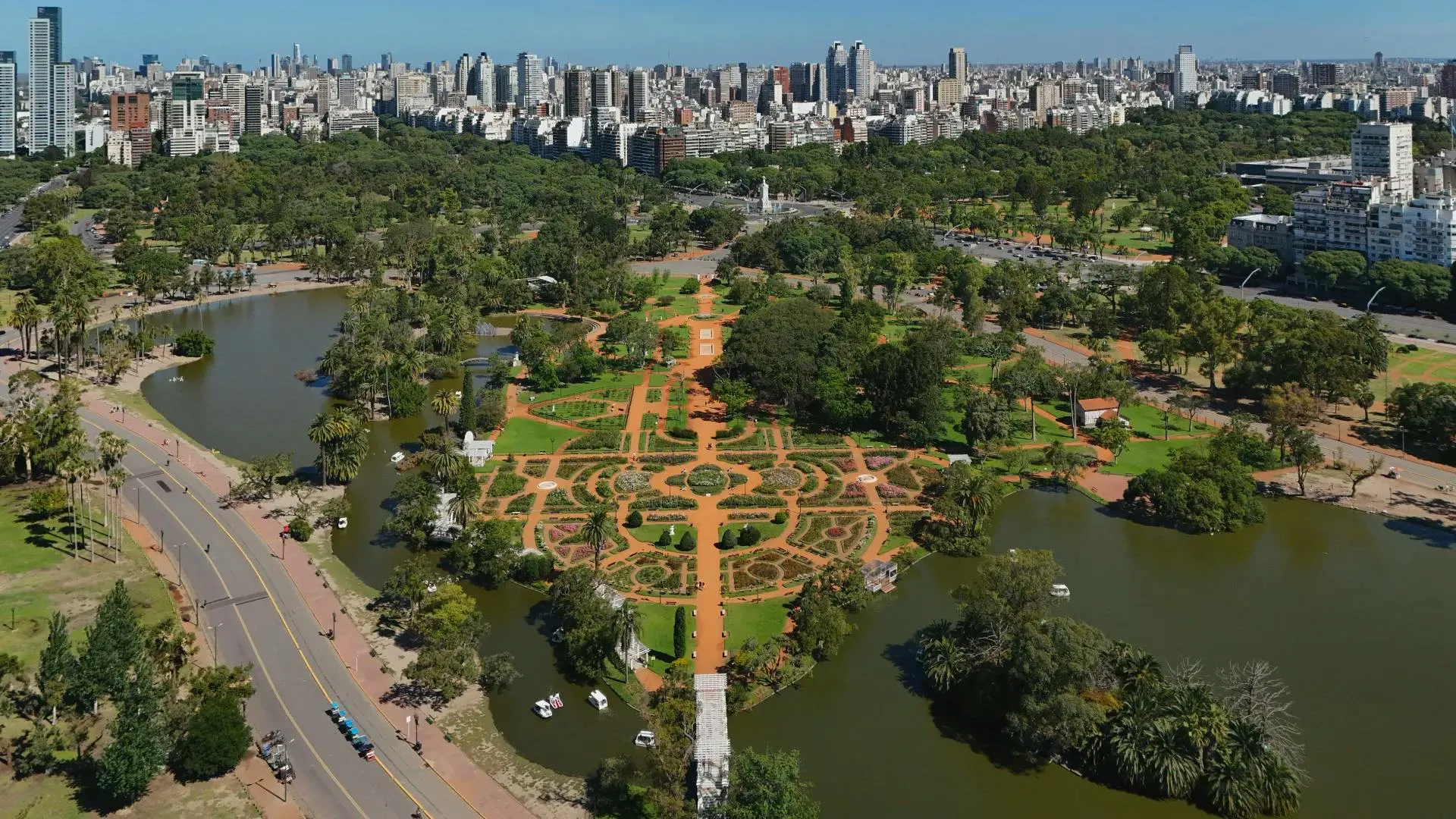 Parco urbano con giardini geometrici, laghi e edifici della città sullo sfondo