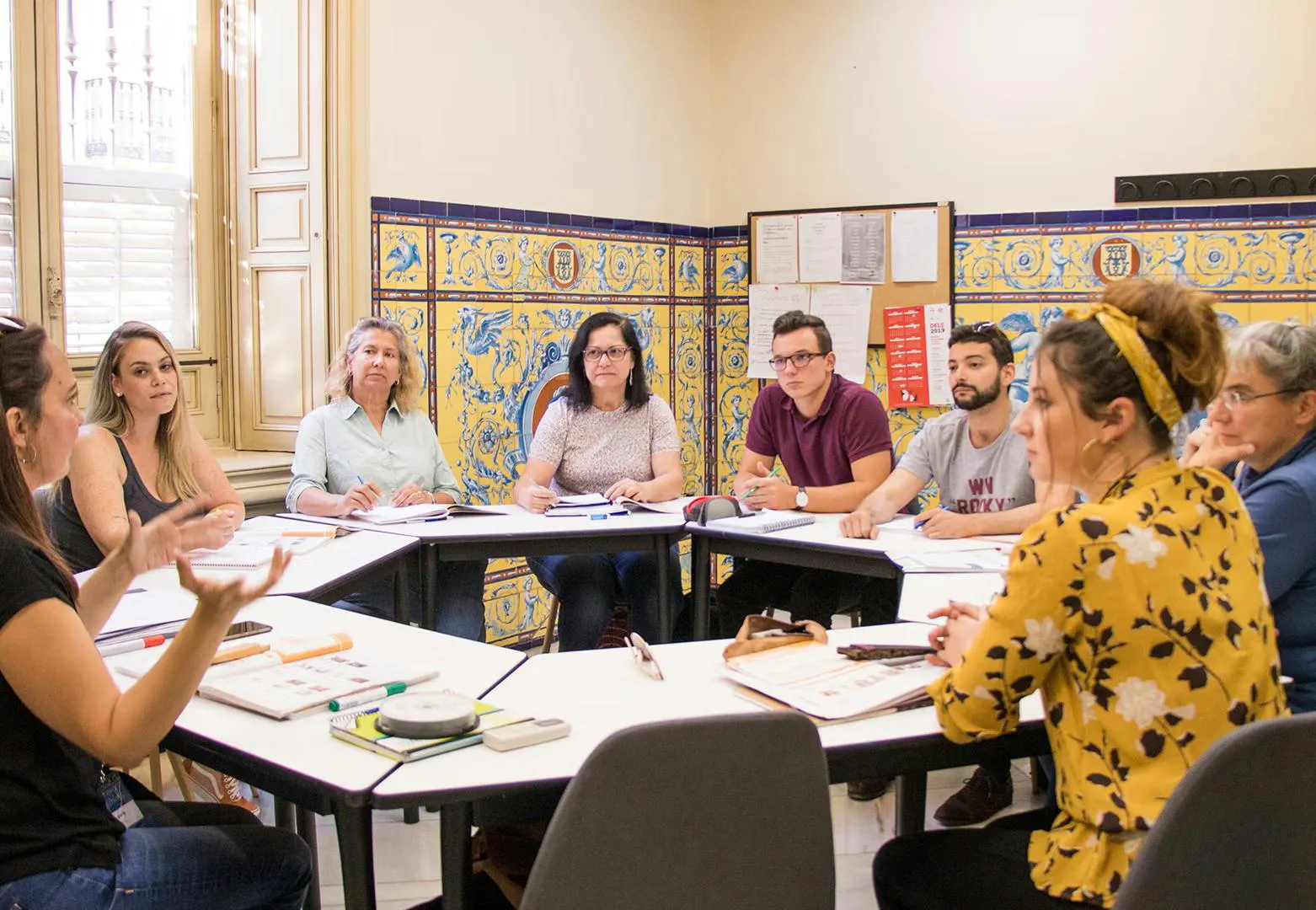 Studenti internazionali che studiano spagnolo insieme nell'atmosfera vivace e accogliente di Seville