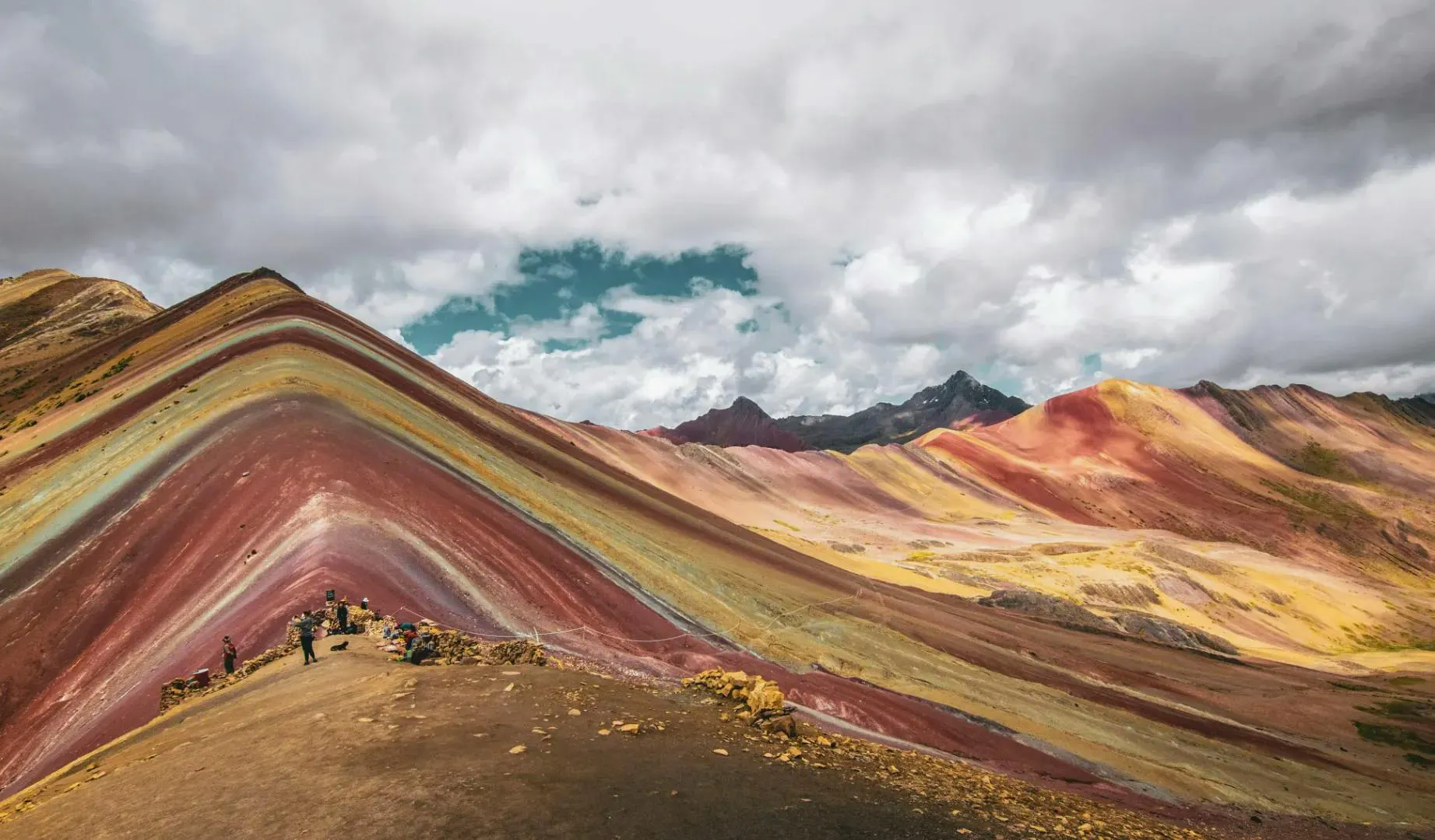 Montagna colorata in Perù circondata da paesaggi andini e cieli nuvolosi