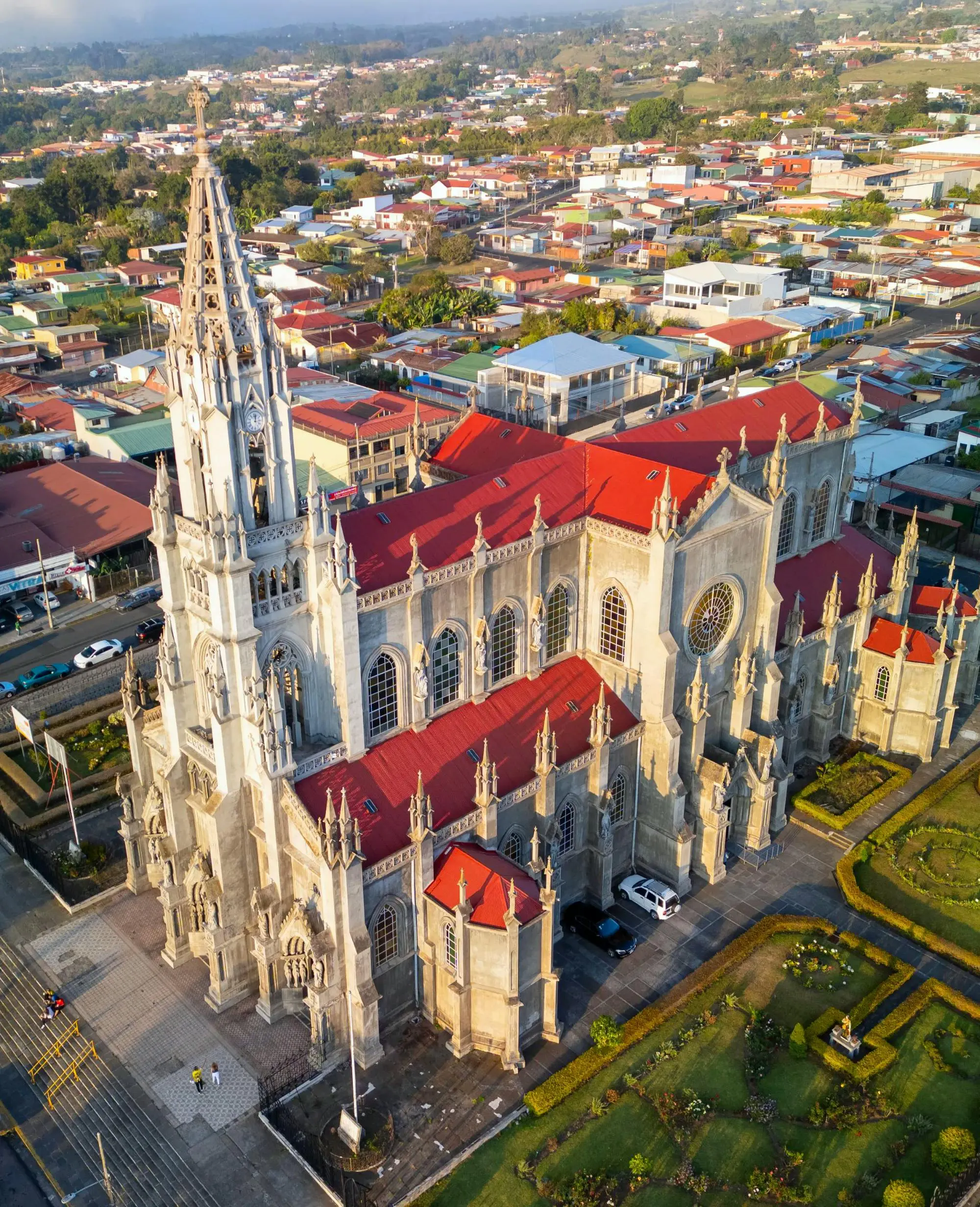 Chiesa neogotica circondata da strade e edifici urbani in una città moderna.