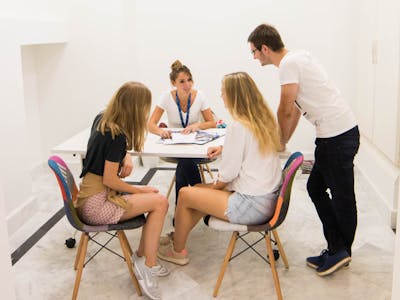 Tre studenti che ricevono assistenza e orientamento per iscriversi a una scuola Enforex, rappresentando il supporto alle iscrizioni degli studenti e i servizi di consulenza per le ammissioni
