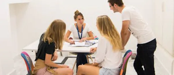 Tre studenti che ricevono assistenza e orientamento per iscriversi a una scuola Enforex, rappresentando il supporto alle iscrizioni degli studenti e i servizi di consulenza per le ammissioni