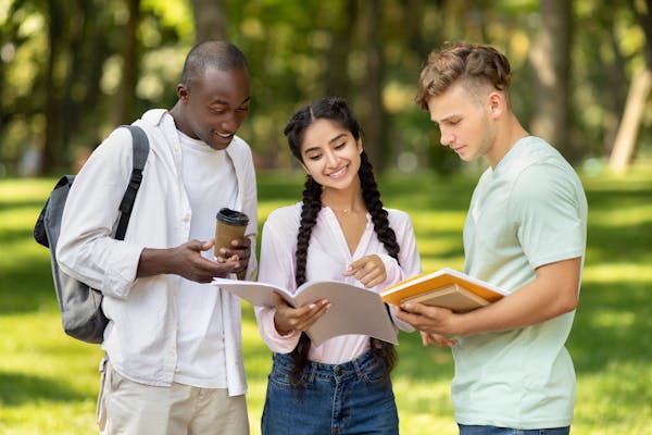 Gruppo eterogeneo di studenti diretti a lezione, che rappresenta borse di studio e sovvenzioni che favoriscono l'accesso all'istruzione superiore e alle opportunità di studio internazionali