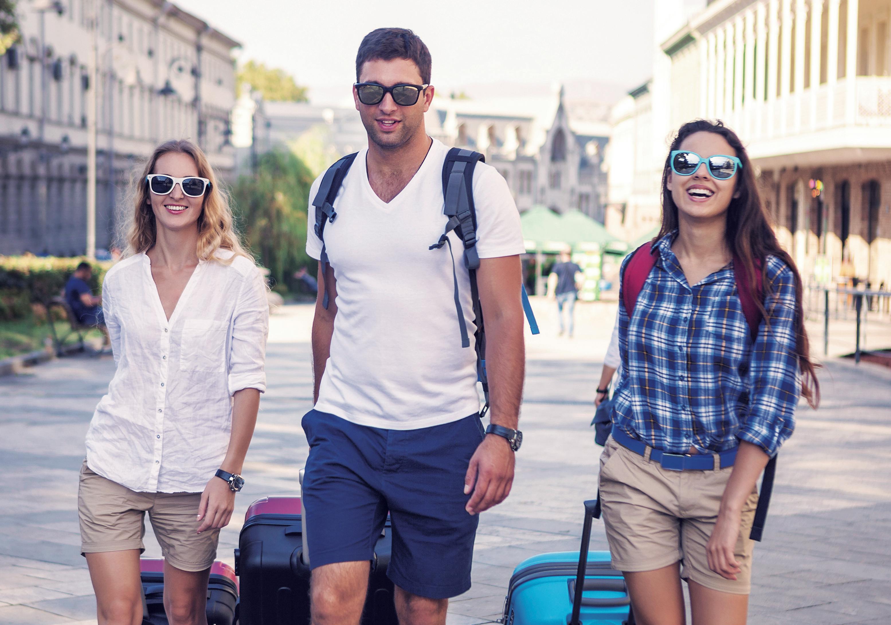 Studenti che camminano insieme con valigie lungo una strada della città durante un viaggio