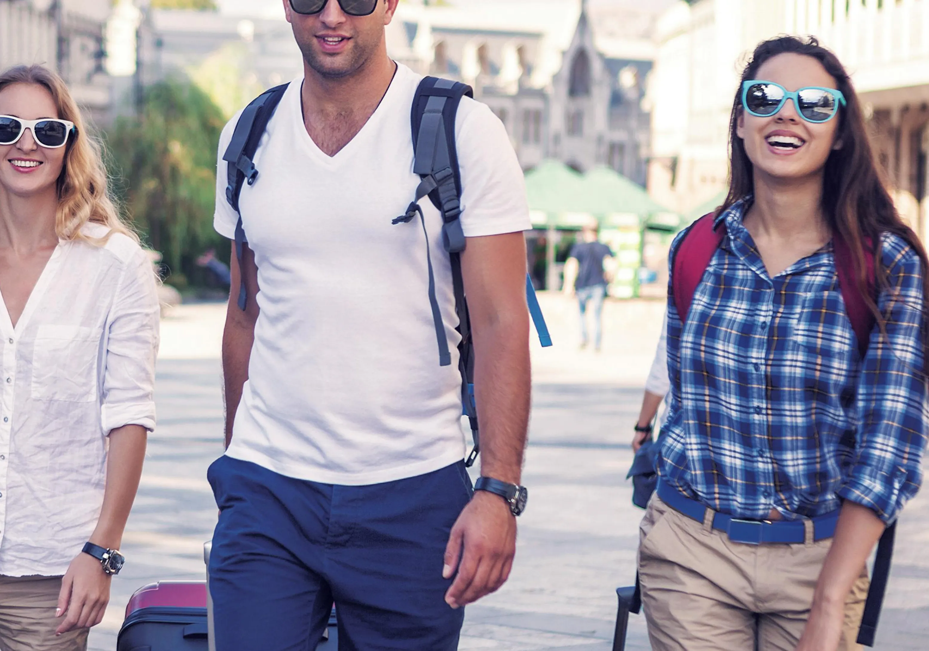 Studenti che camminano insieme con valigie lungo una strada della città durante un viaggio