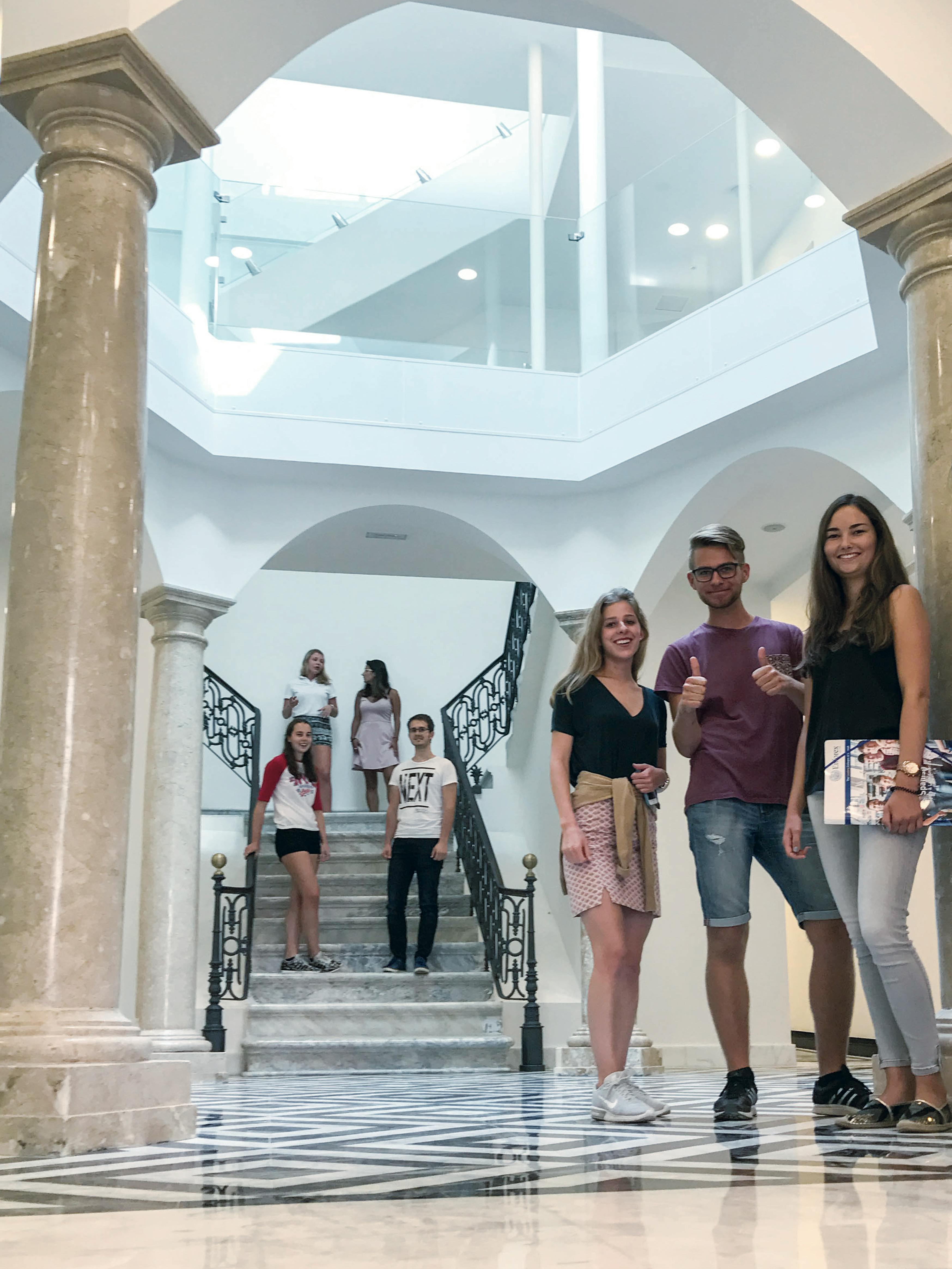 Studenti che camminano e socializzano all'interno di un edificio scolastico luminoso e moderno