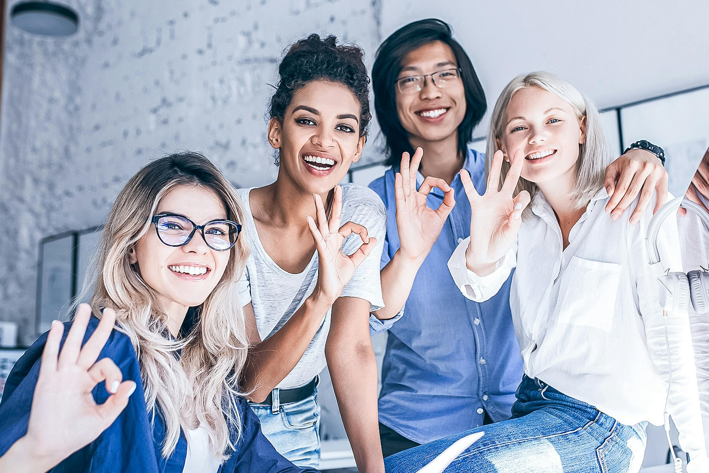 Gruppo di studenti che sorridono e fanno gesti di approvazione in un'atmosfera divertente