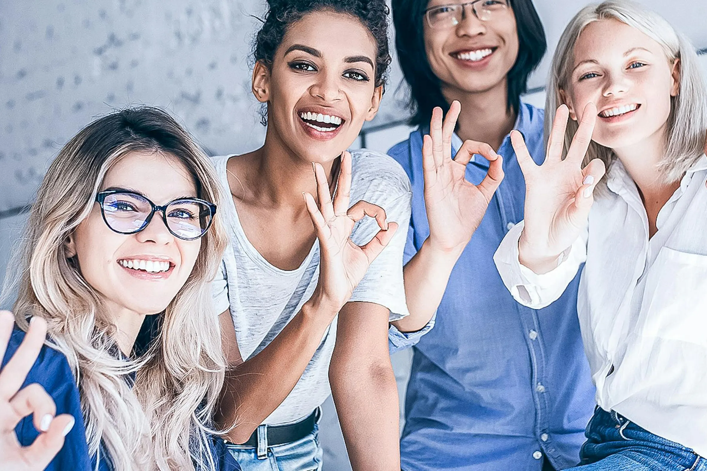 Gruppo di studenti che sorridono e fanno gesti di approvazione in un'atmosfera divertente