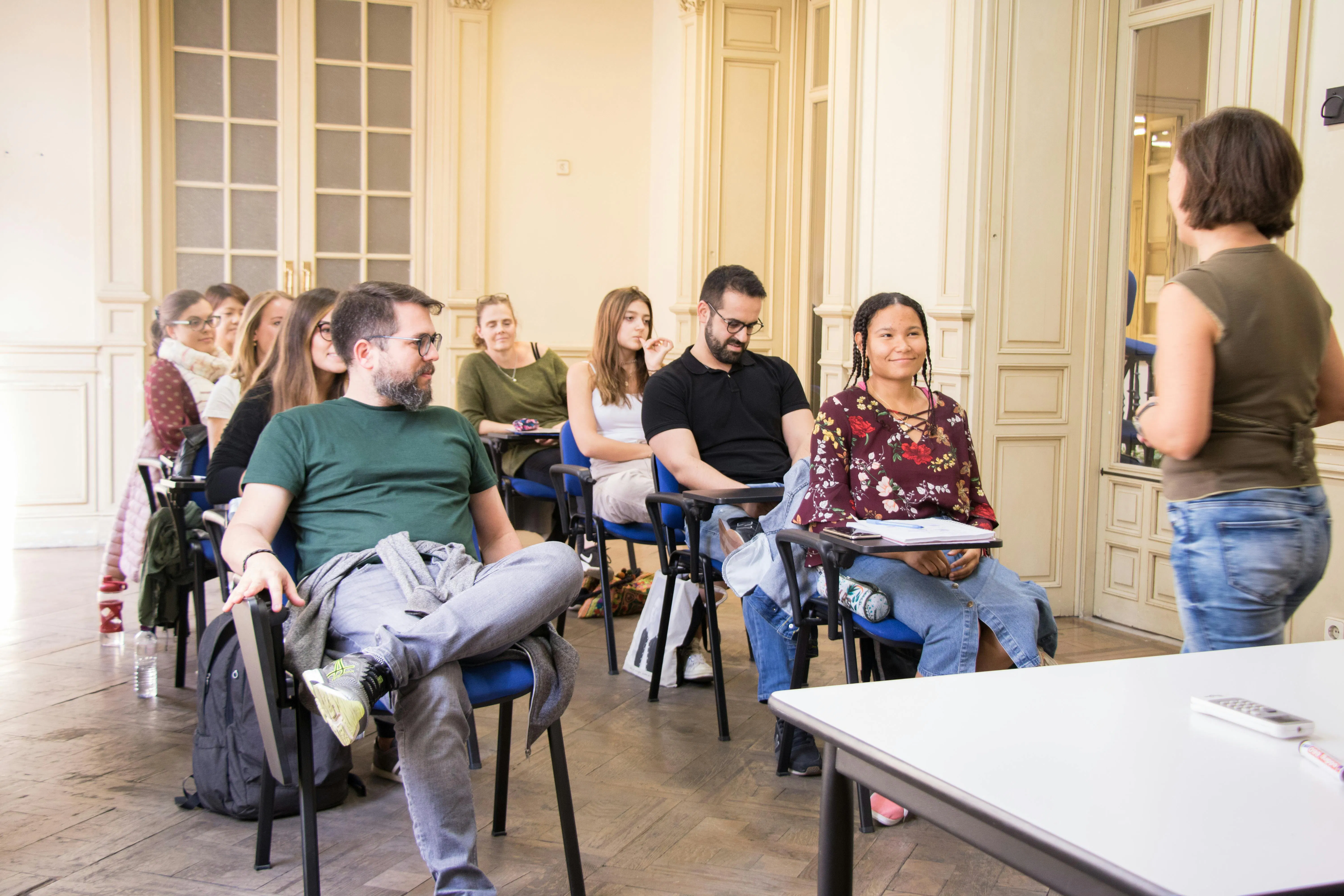 学生たちが、歓迎的なセビリア校のインタラクティブな教室で一緒にスペイン語を学んでいる