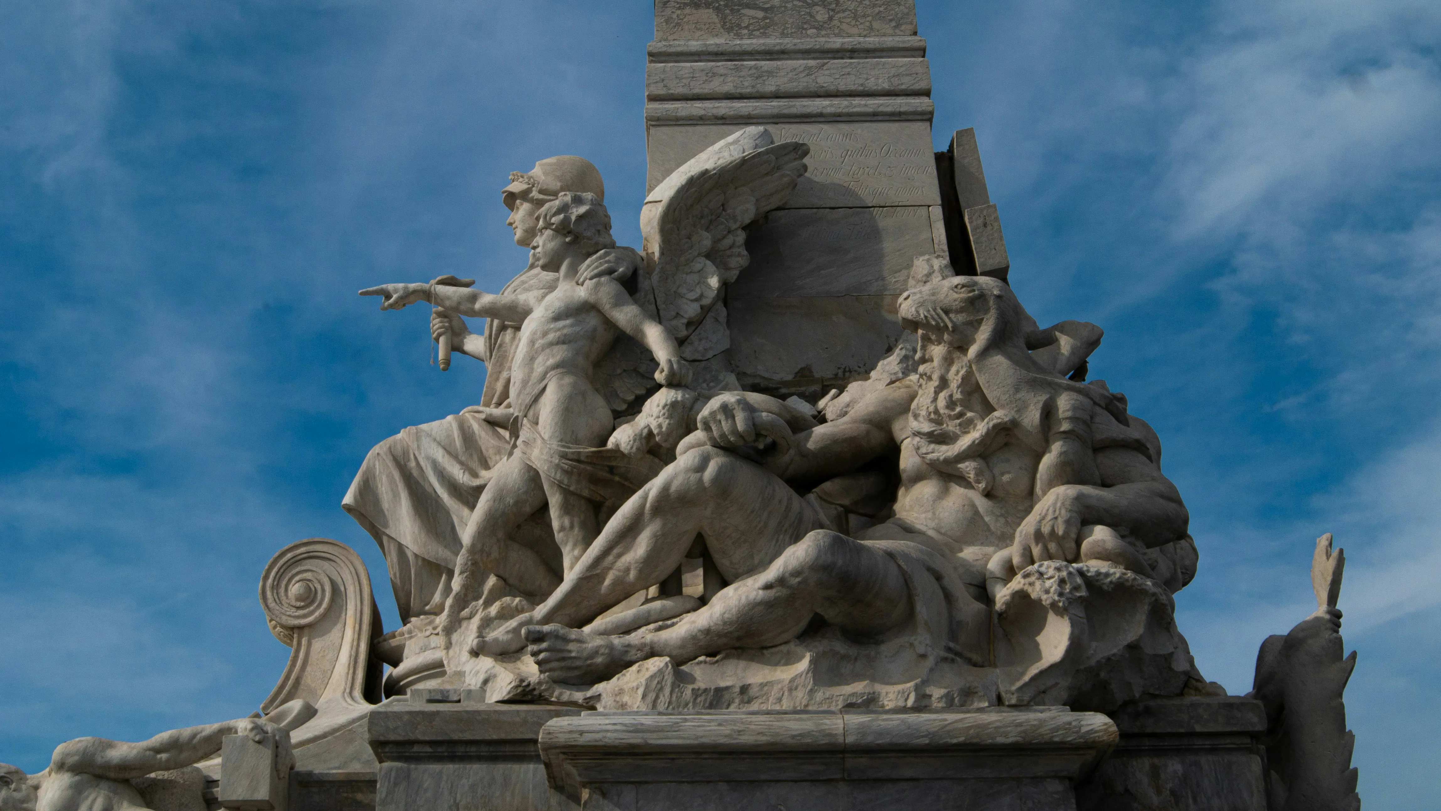 una statua di un uomo che tiene un fucile davanti a un cielo azzurro