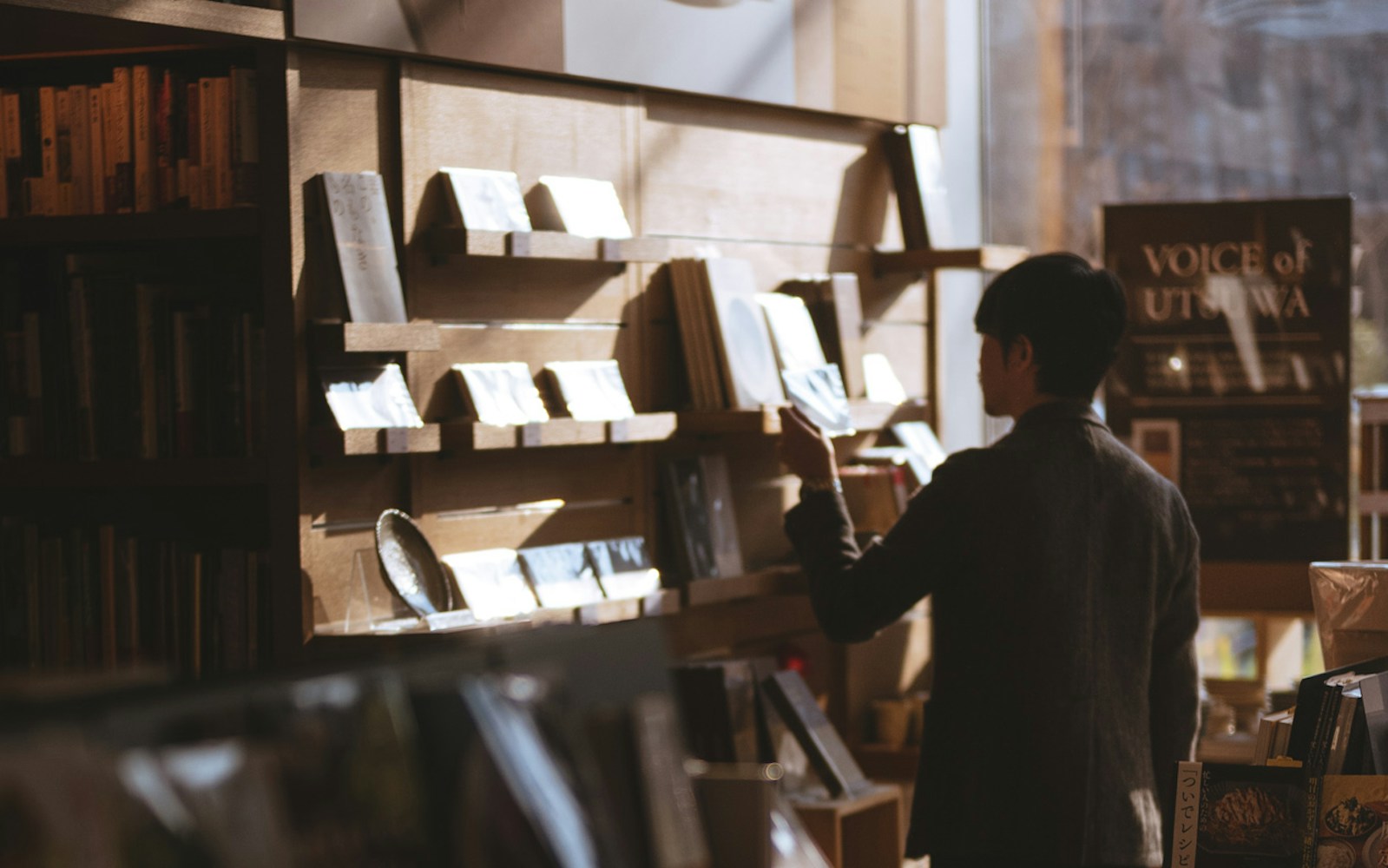 uomo in una biblioteca che cerca libri