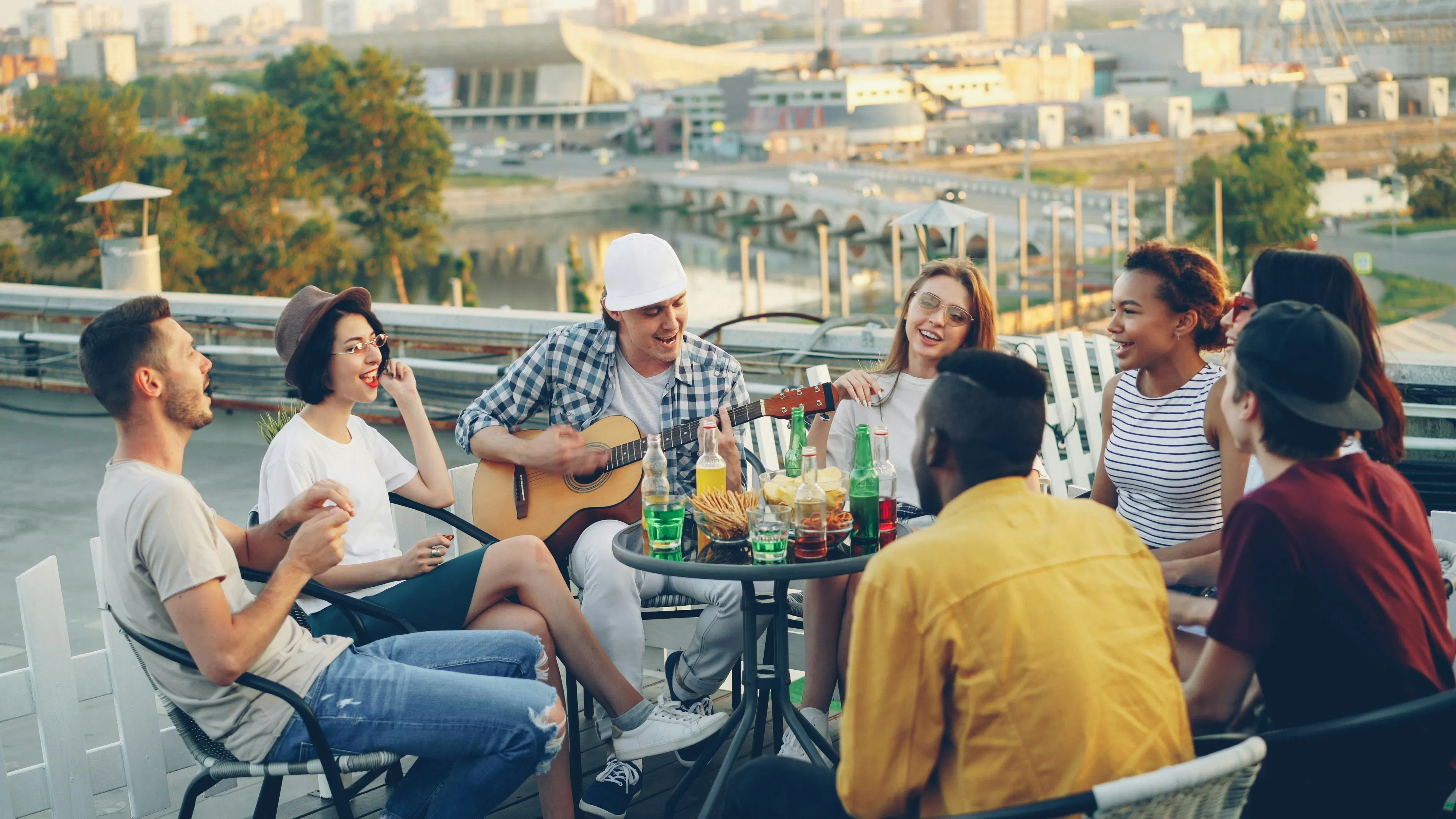 Amici che si godono un ritrovo sul tetto con musica e bevande