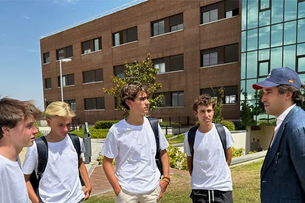 Grupo do programa de liderança com quatro estudantes e Fernando Alonso, em frente ao campus da Universidad Francisco de Vitoria.