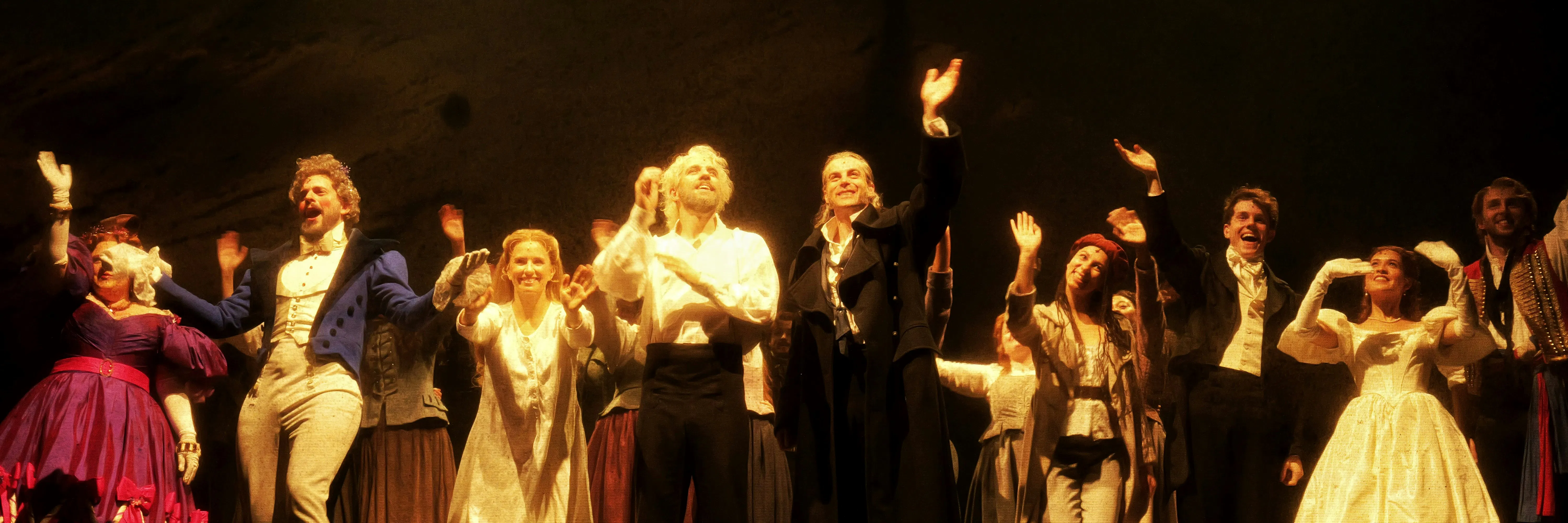 Eine Gruppe von Menschen in historischen Kostümen auf der Bühne.