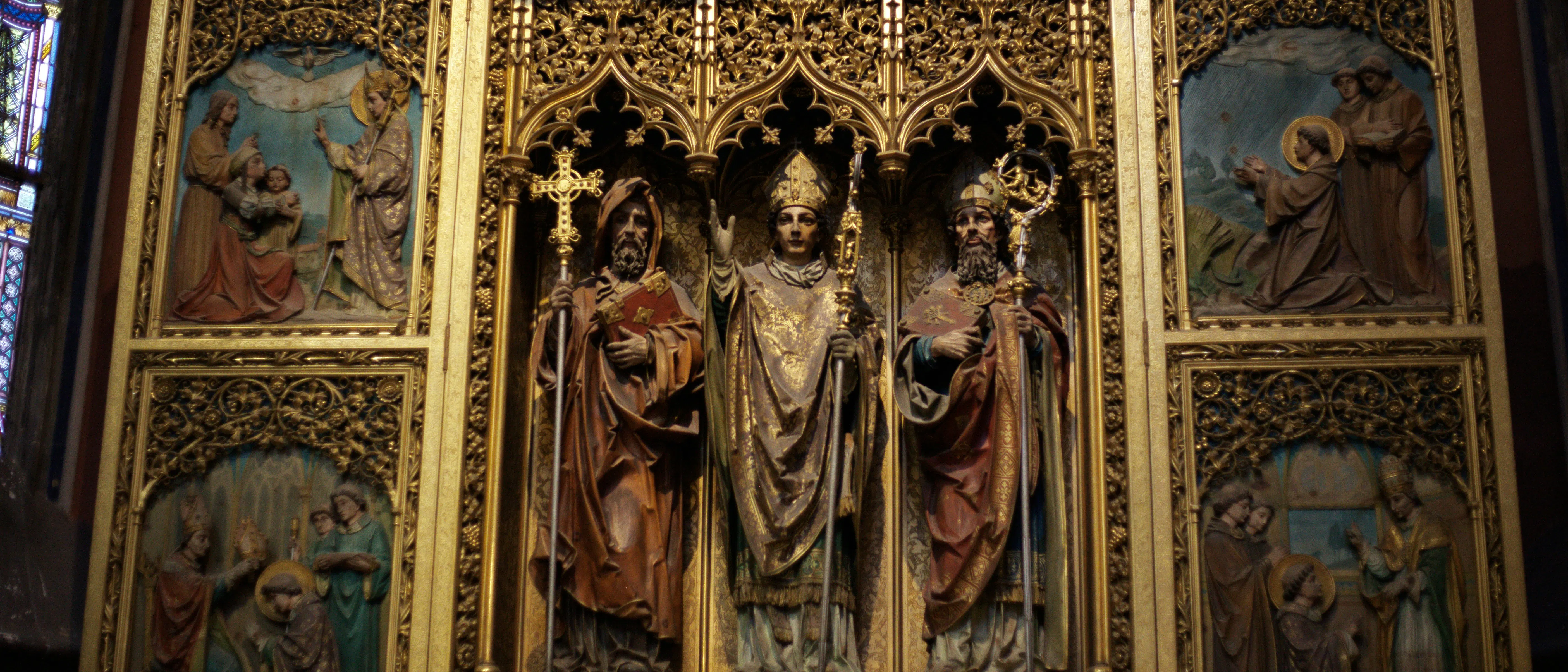 Altare dorato ornato con figure religiose e intagli.