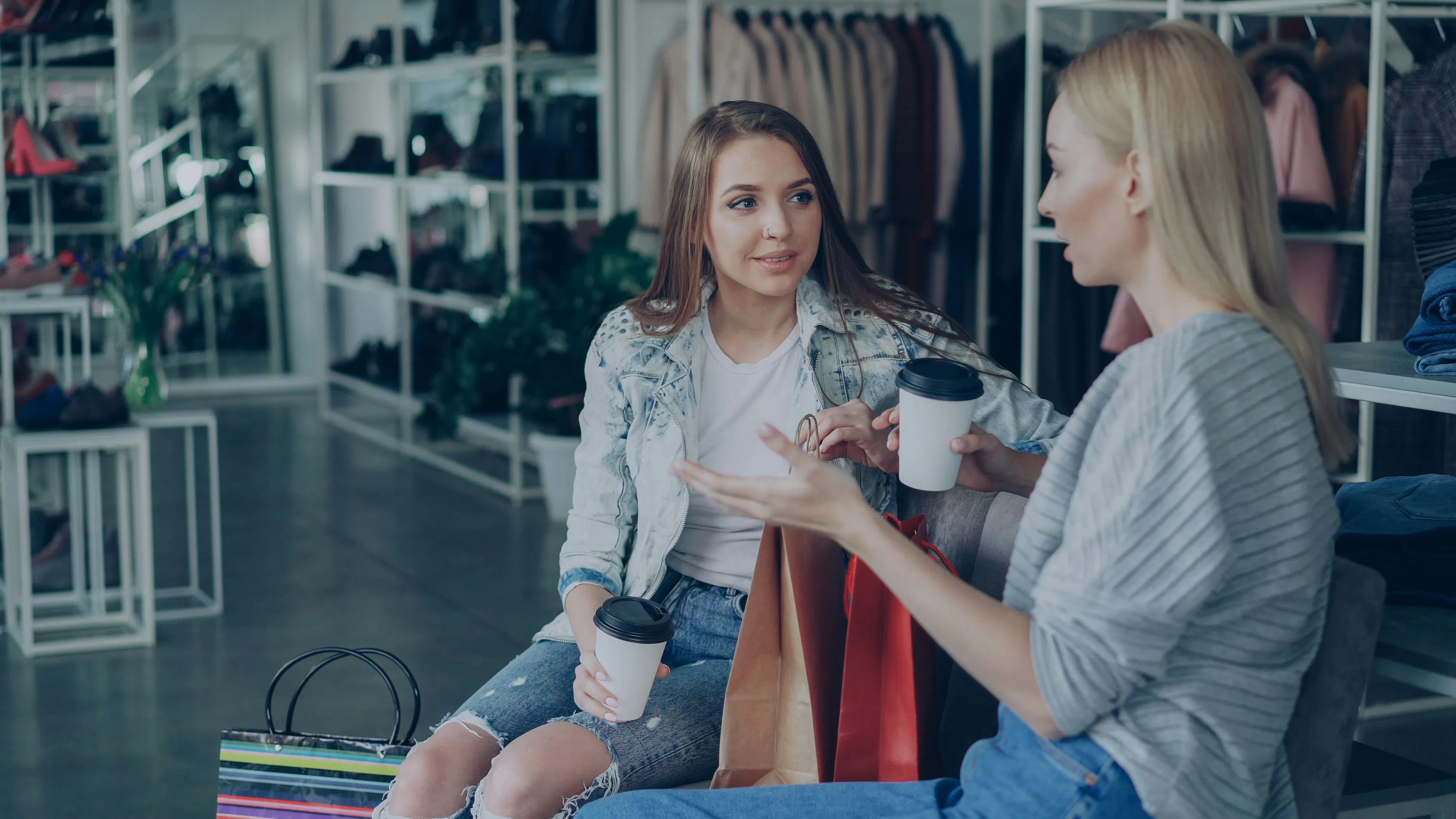 Due donne chiacchierano mentre si riposano in una boutique.